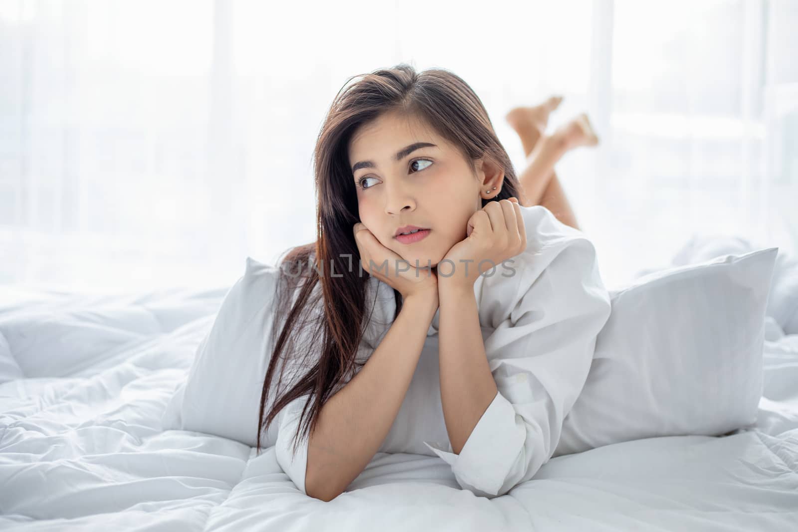 Asian woman Beautiful young smiling woman sitting and sleeping in white bed and stretching in the morning at bedroom after waking up in her bed fully rested