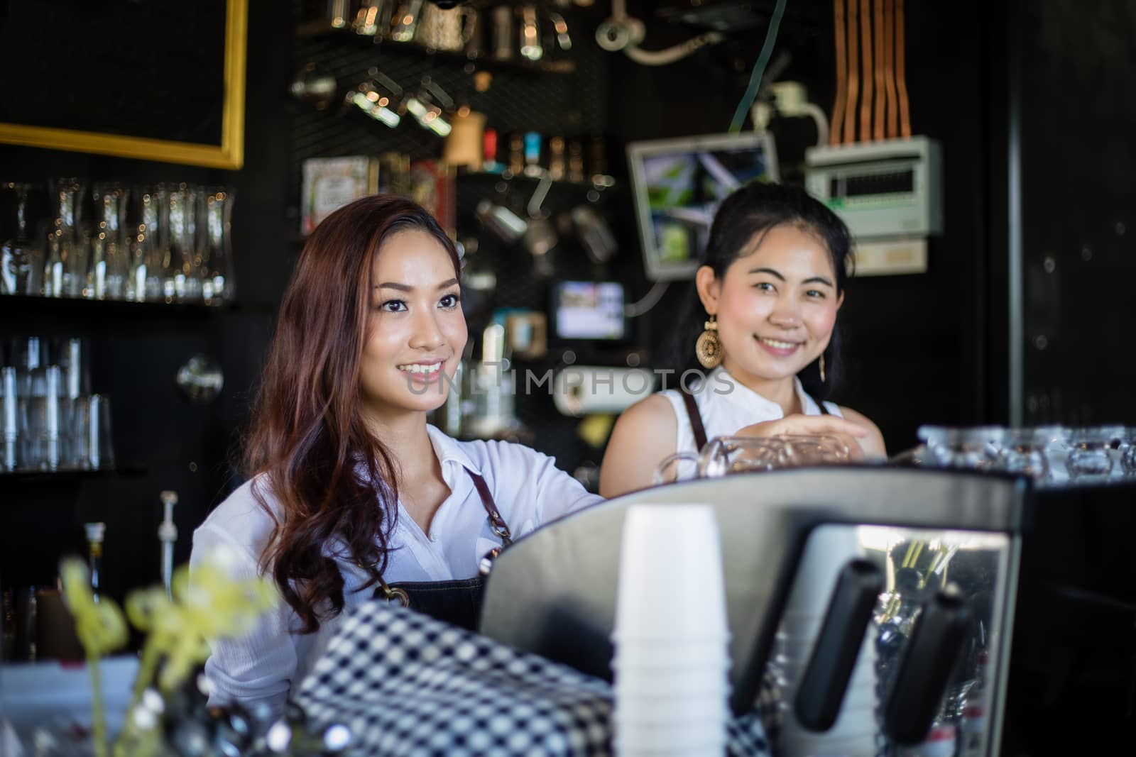 Asian women Barista smiling and using coffee machine in coffee shop counter - Working woman small business owner food and drink cafe concept