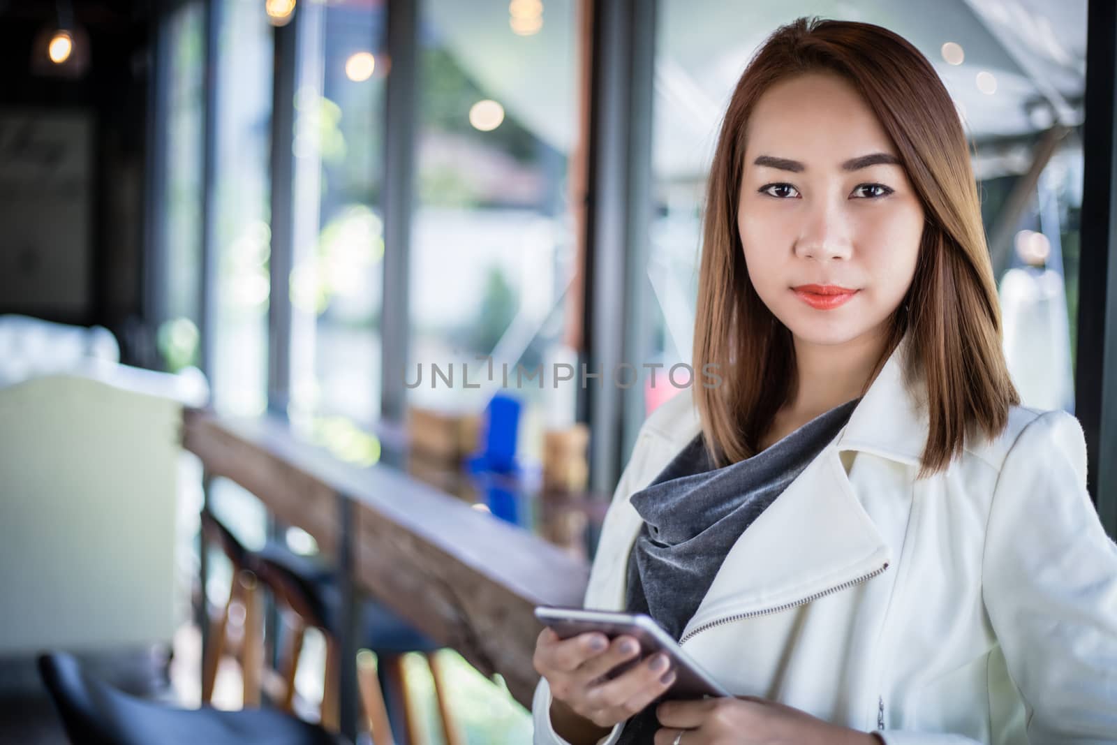 woman asian using phone for shopping online and calling with cell telephone in coffee shop during free time