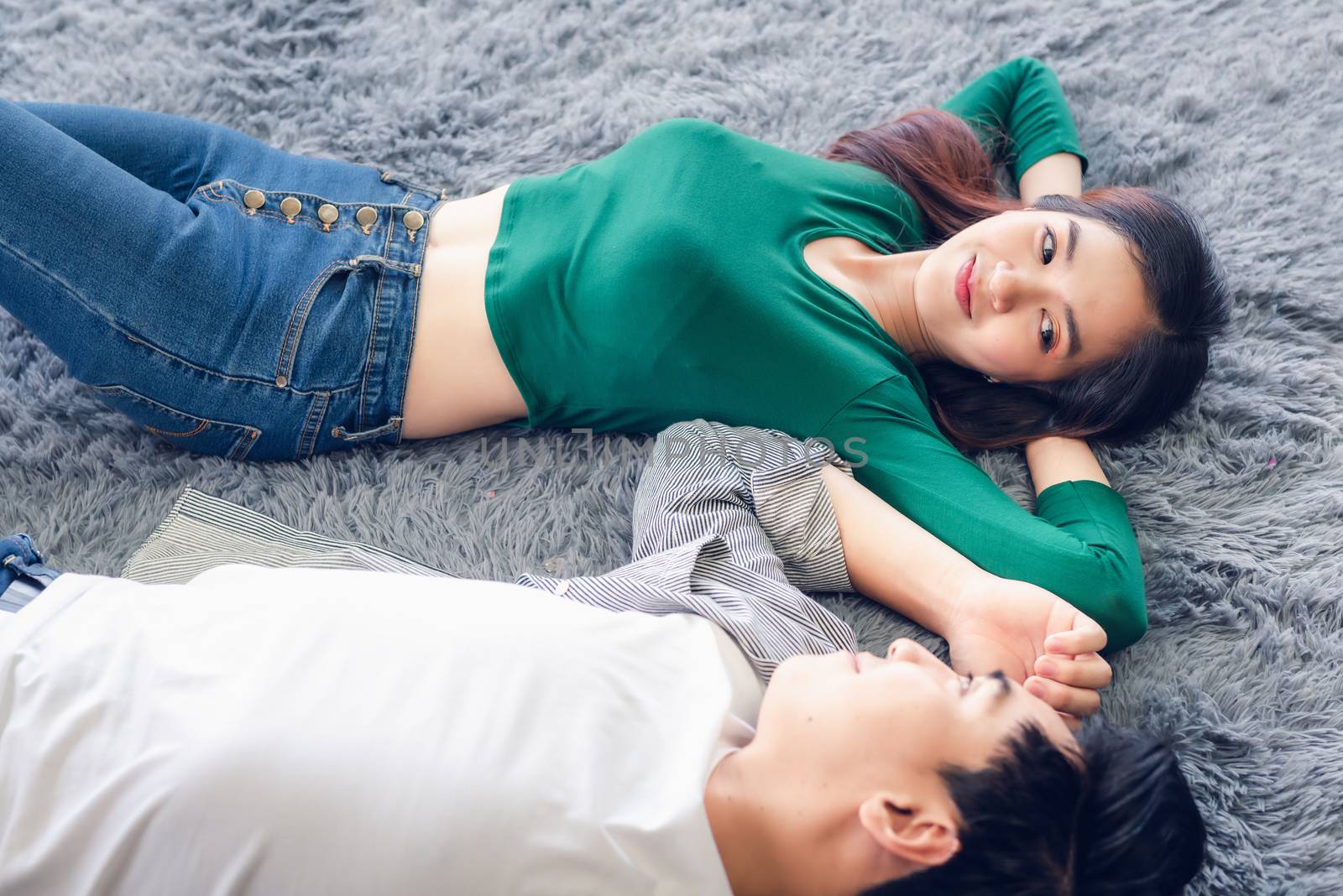 Young Couple Having Relaxing While Lying on Carpet at Their Home, Attractive Asian Couple Love are Relaxed Together on Living Room Flooring. Happy Moments and Lifestyles Concept