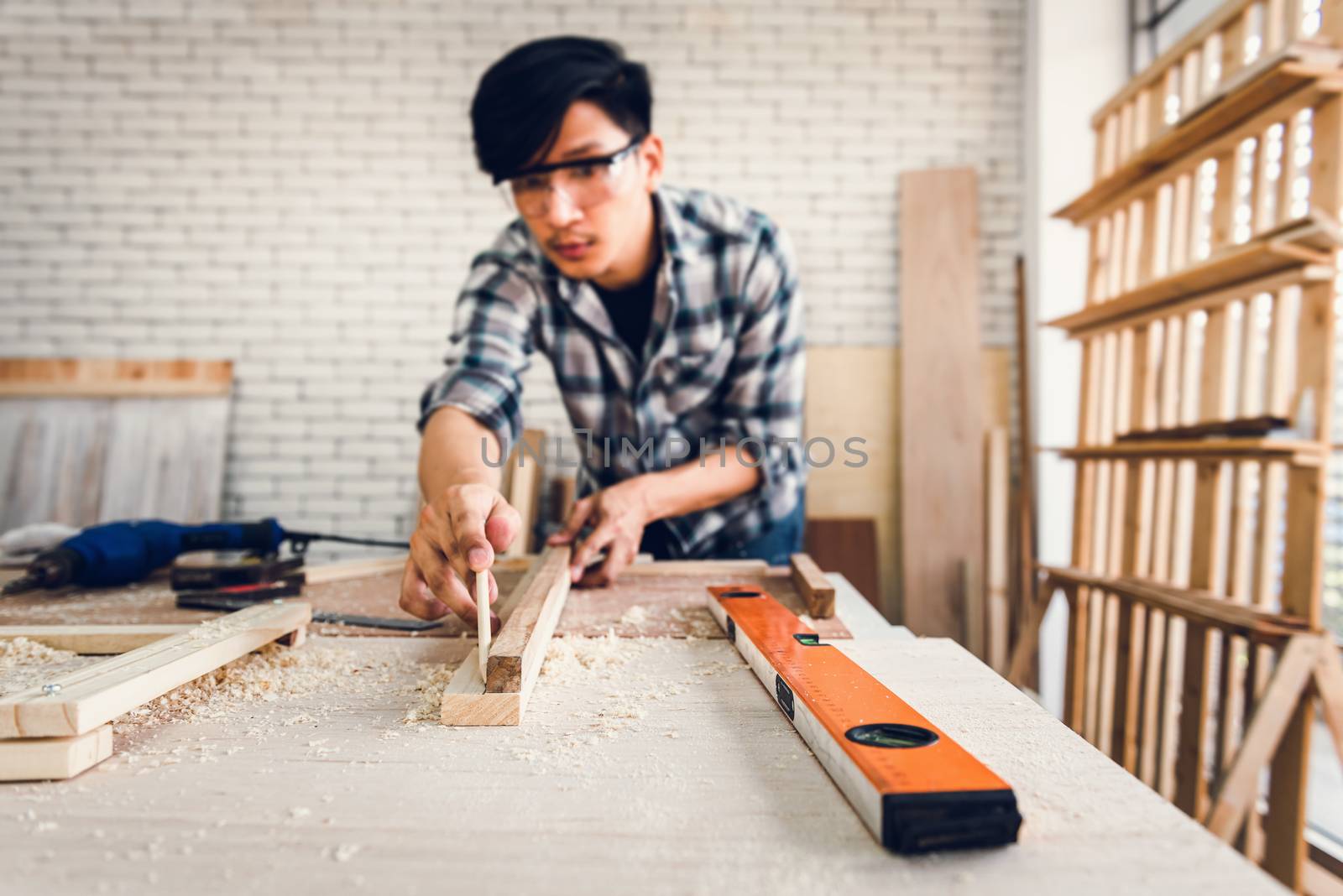 Carpenter Man is Working Timber Woodworking in Carpentry Shop, Craftsman is Screw Coring Timber Frame for Wooden Furniture in Workshop. Workmanship and Job Occupation Concept by MahaHeang245789