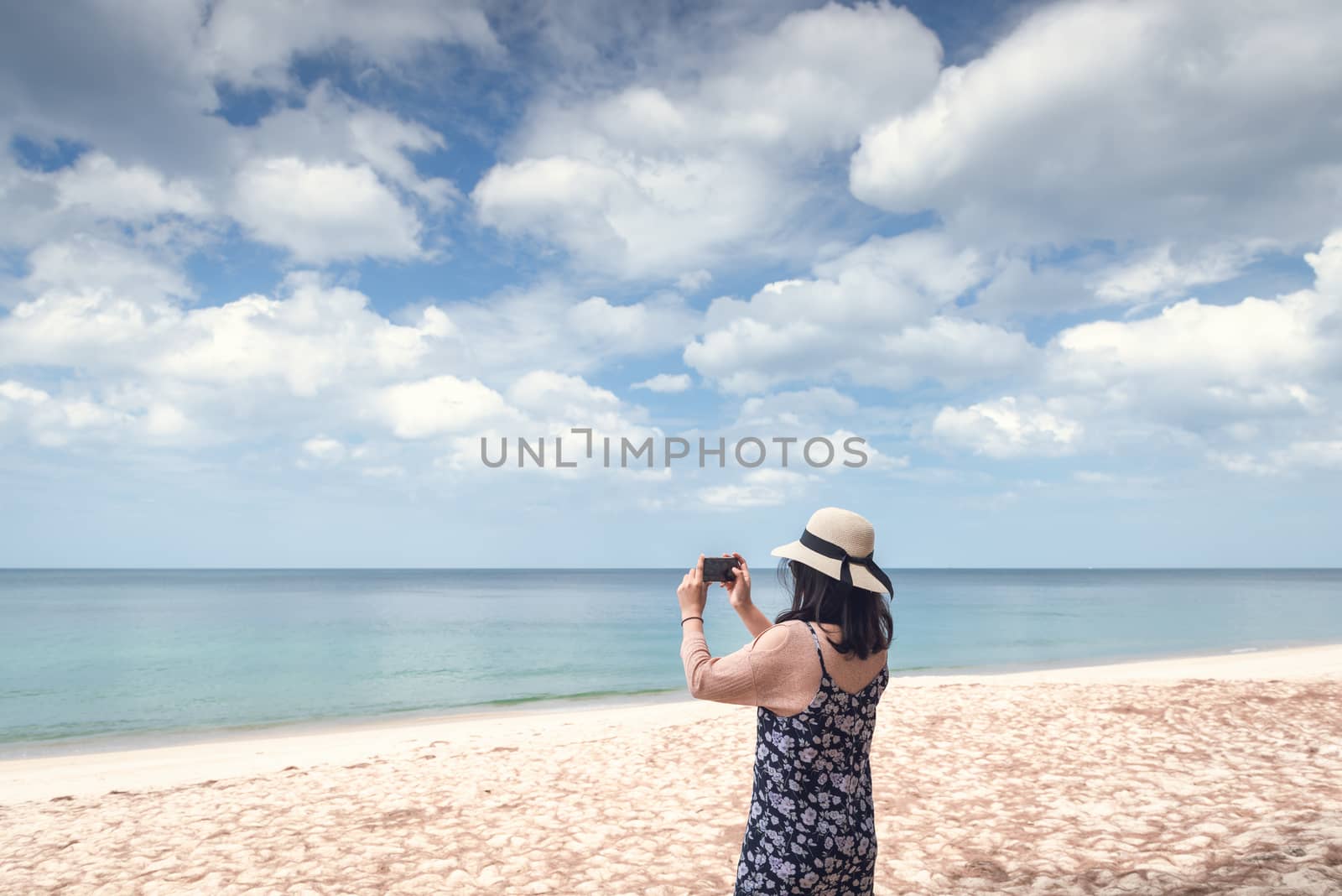 Portrait of Asian Woman is Using Mobile Phone for Capturing Natural Scenery at The Beach, Beautiful Woman is Having Fun and Enjoying With Her Phone in Summer Vacation on The Beach. Relaxing Lifestyles