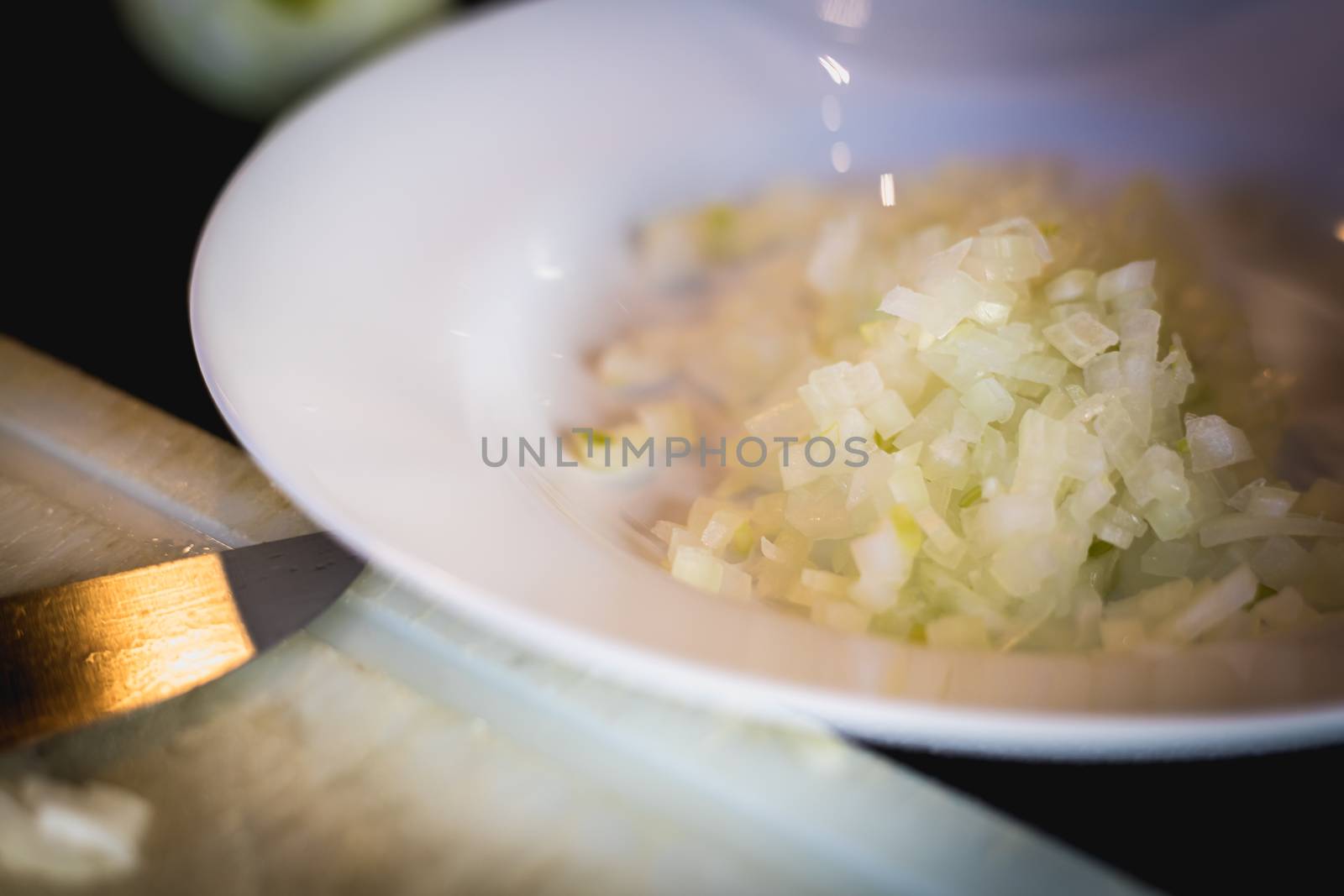 woman cuts onions on a white plastic board  by AtlanticEUROSTOXX