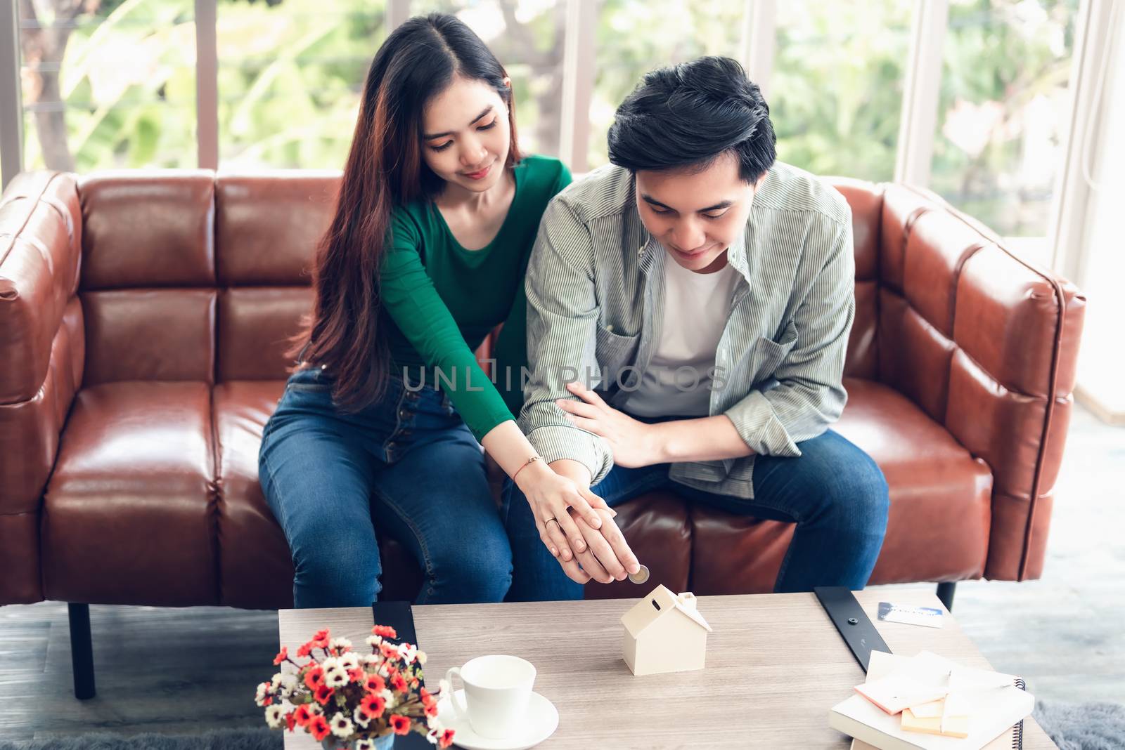 Portrait of Couple Love are Putting Money Coin into House Saving for Future Real Estate Together., Housing Insurance and Residential Loan Investment Concept. by MahaHeang245789