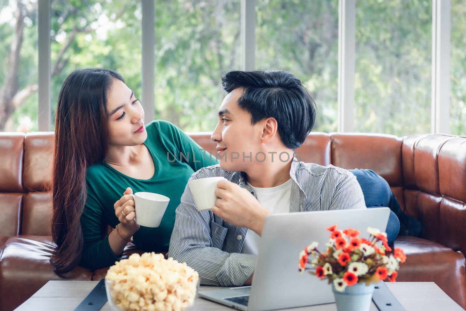 Couple Love Having Relaxation Discussing While Drinking a Coffee in Their Home, Attractive Asian Couple Happiness in Romantic Moments at Living Room. Relaxing and Lifestyles Concept