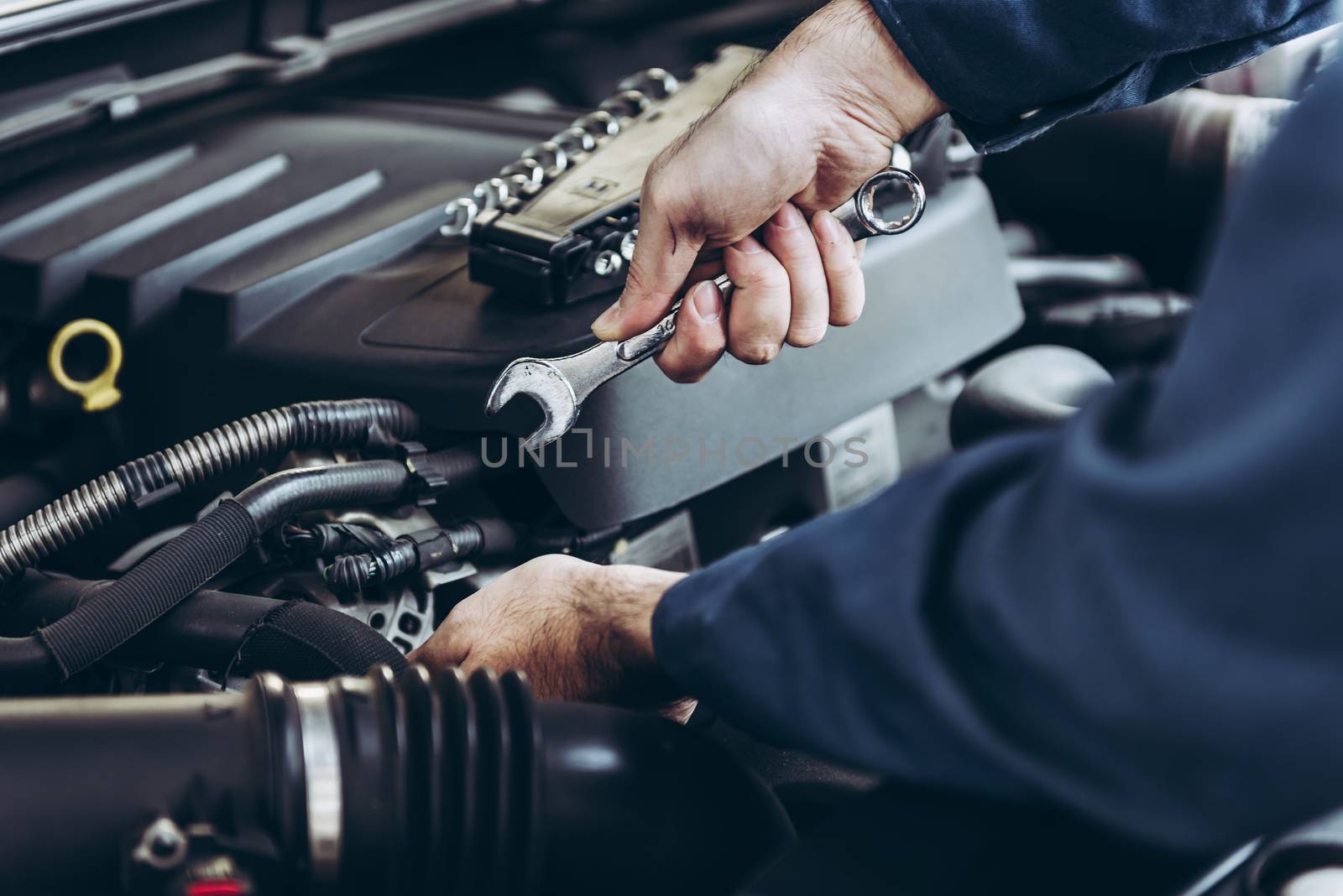 Mechanic Car Service Man is Working in Garage Workshop, Close-Up of Technician Automotive Hand is Inspection Checking and Repairing Mechanical Car Engine. Auto Services and Maintenance Concept by MahaHeang245789