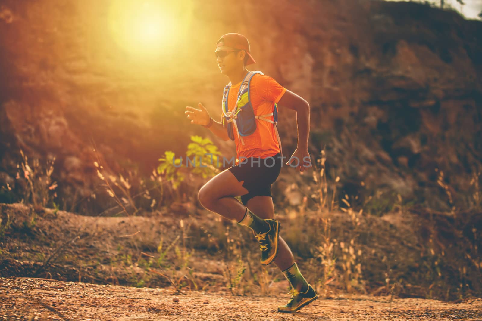 A man Runner of Trail and athlete's feet wearing sports shoes for trail running in the mountain