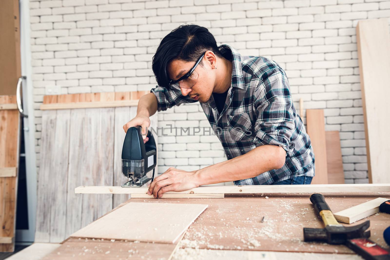 Carpenter Man is Working Timber Woodworking in Carpentry Workshops, Craftsman is Measuring Timber Frame for Wooden Furniture in Workshop. Workmanship and Job Occupation Concept by MahaHeang245789