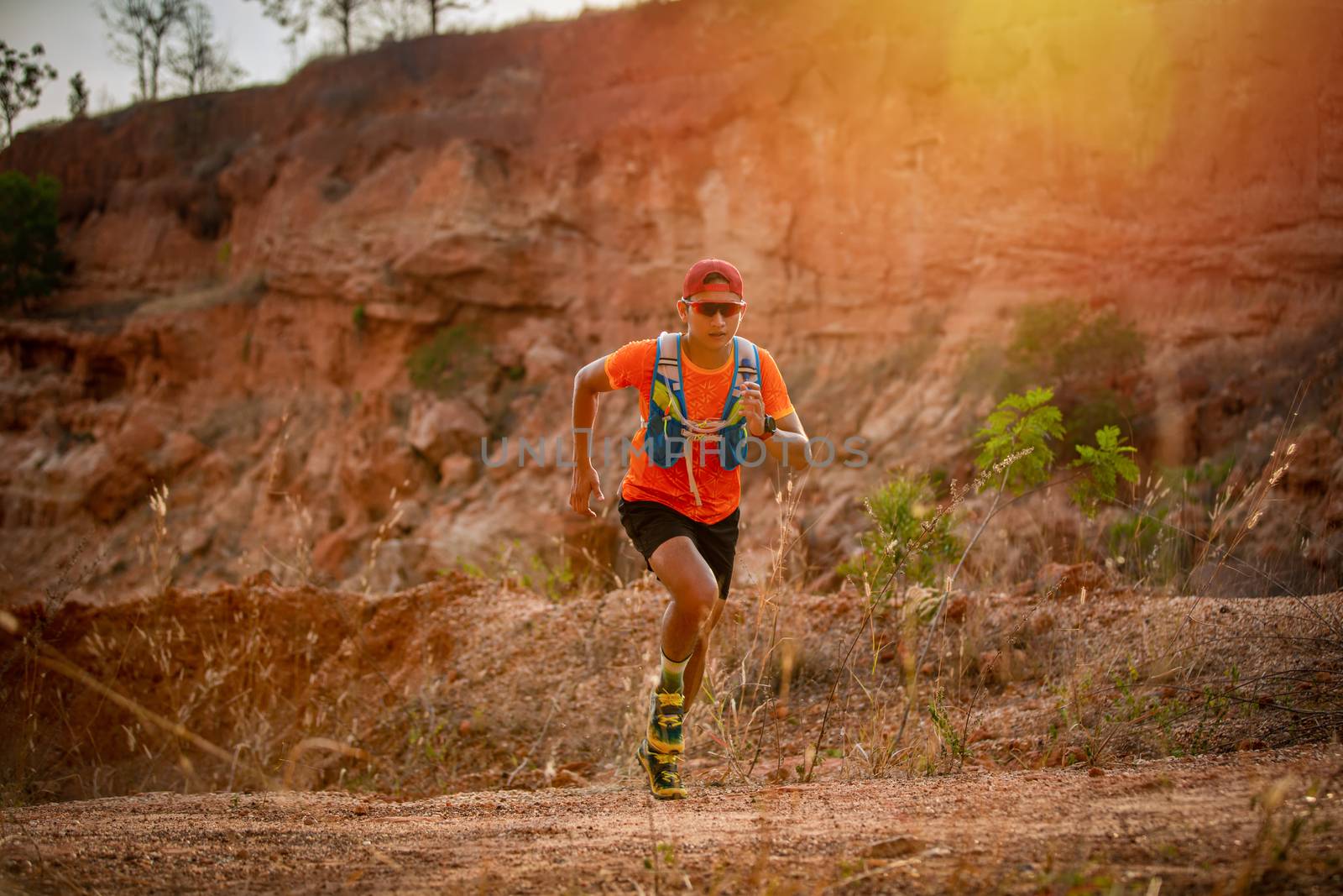 A man Runner of Trail and athlete's feet wearing sports shoes for trail running in the mountain