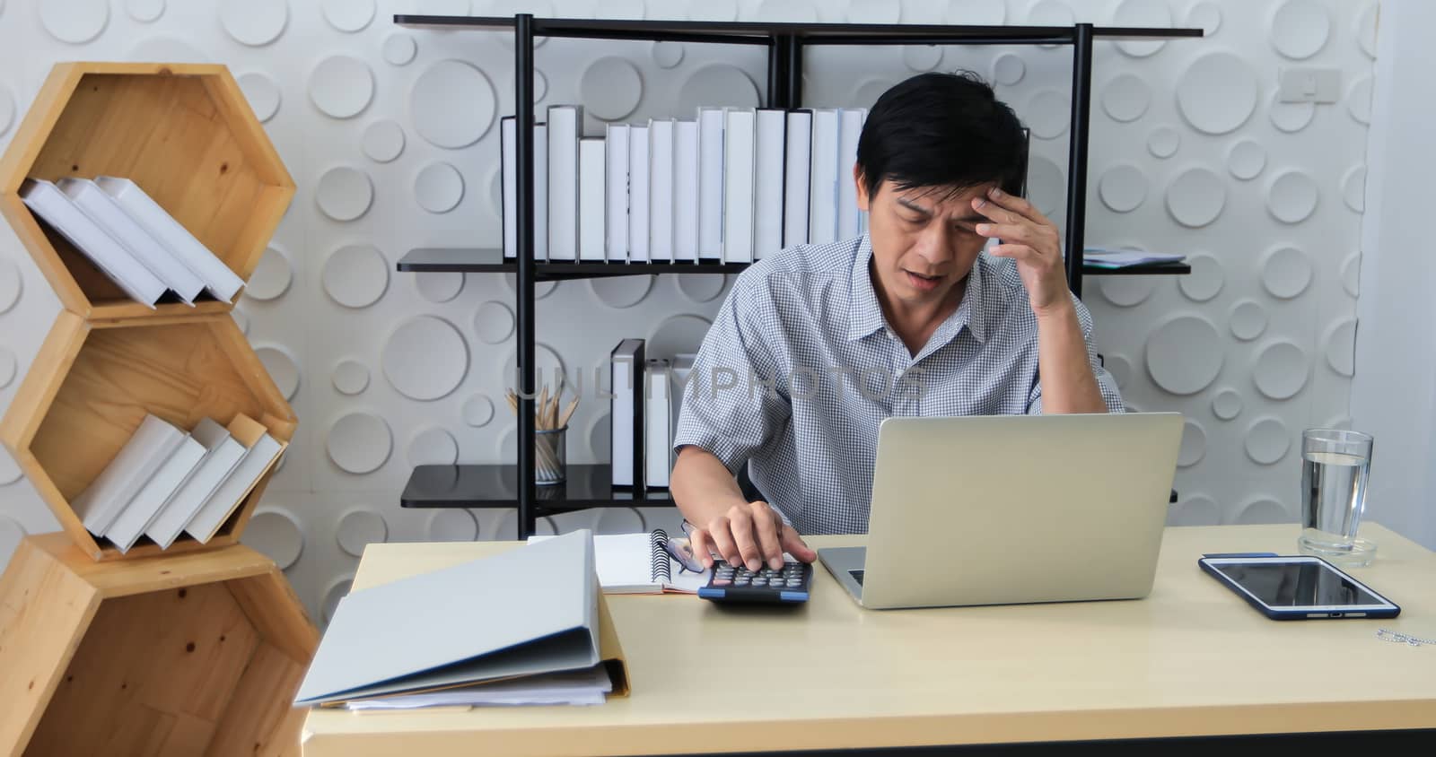 A senior Asian man using notebook for working and businesswoman serious about the work done until the headache