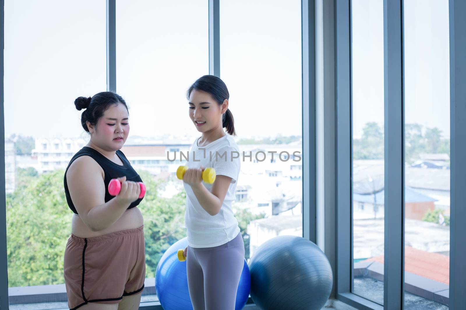 Asian Fat woman and trainer work out in the fitness class and The trainer recommends exercise for weight loss for obese women by Tuiphotoengineer