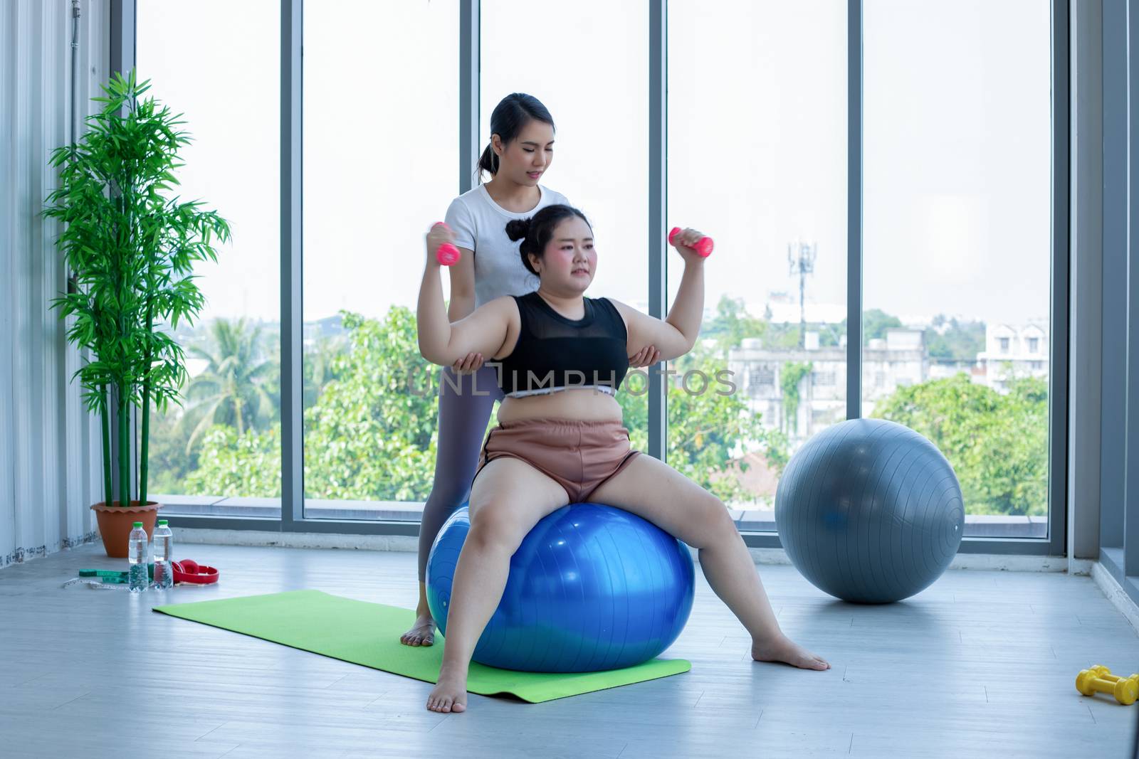 Asian Fat woman and trainer work out in the fitness class and The trainer recommends exercise for weight loss for obese women by Tuiphotoengineer