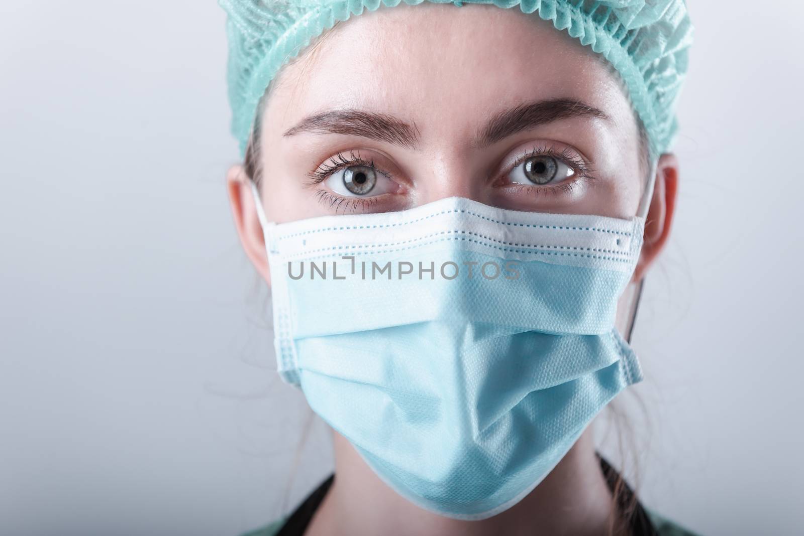 Female Doctor in Protective Mask and Medical Cap on Isolated Background, Closeup Portrait of Medicine Surgeon Doctor Wearing Medical Mask With Copy Space. Clinical Health Care/Doctors Occupation