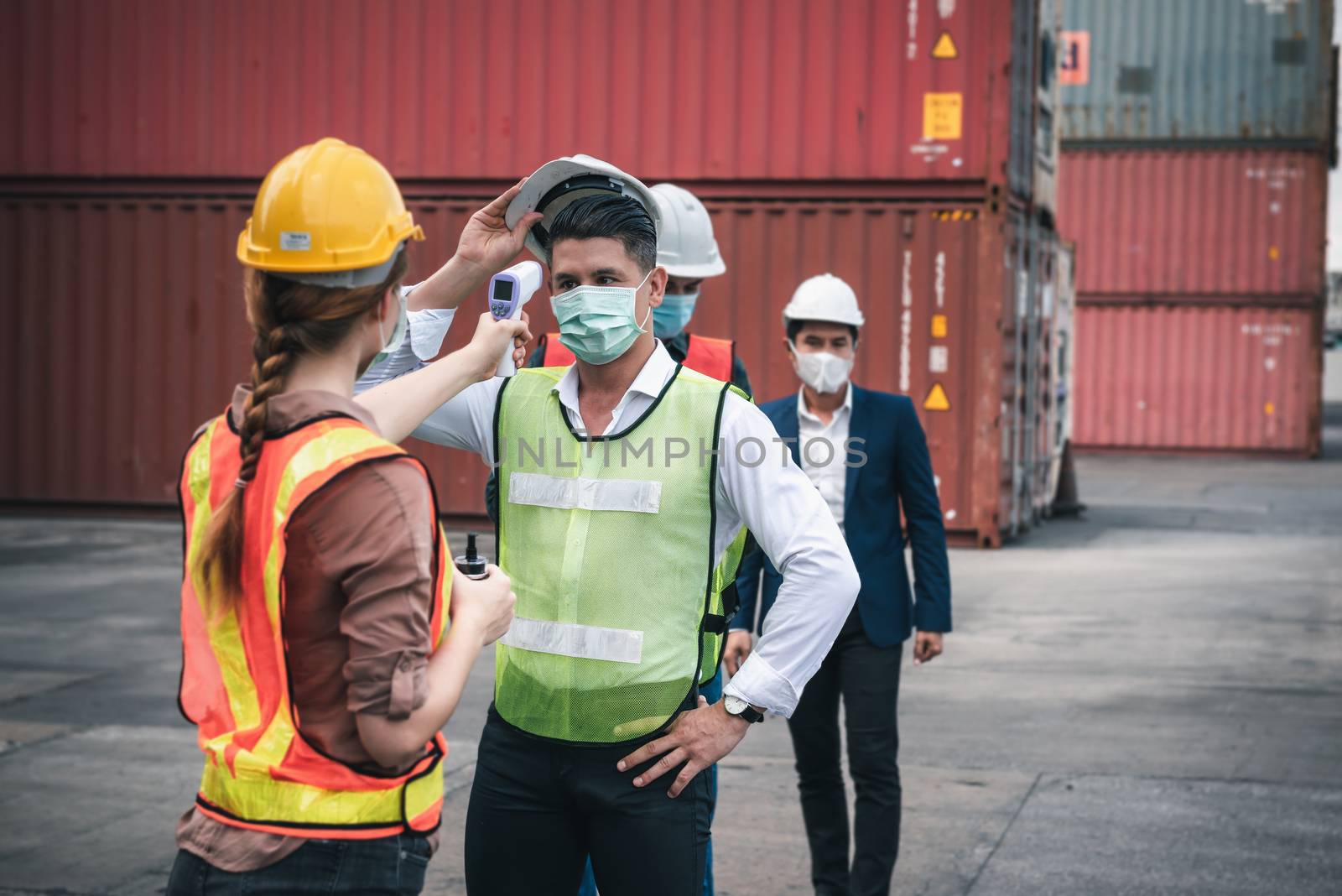 Coronavirus Covid-19 Disease Epidemic Crisis Situation, Container Shipping Worker Having Fever Body Scan by Thermometer Scanning at Ship Yard. Corona-Virus Covid19 Prevention of New Normal Concept