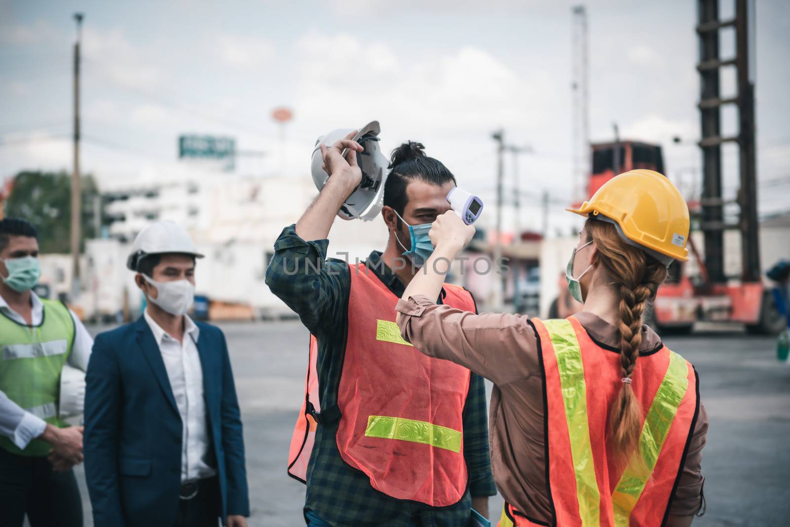 Coronavirus Covid-19 Disease Epidemic Crisis Situation, Construction Worker Having Fever Body Scan by Thermometer Scanning at Construction Site. Corona-Virus Covid19 Prevention of New Normal Concept by MahaHeang245789