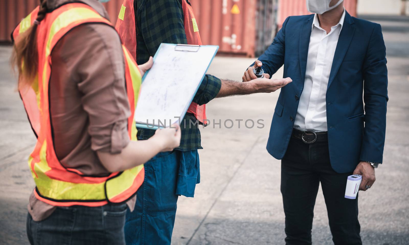 Coronavirus Covid-19 Disease Epidemic Crisis Situation, Container Shipping Worker Having Alcohol Gel Hands Cleaning Before Working at Warehouse Ship.Corona-Virus Covid19 Prevention/ New Normal Concept by MahaHeang245789