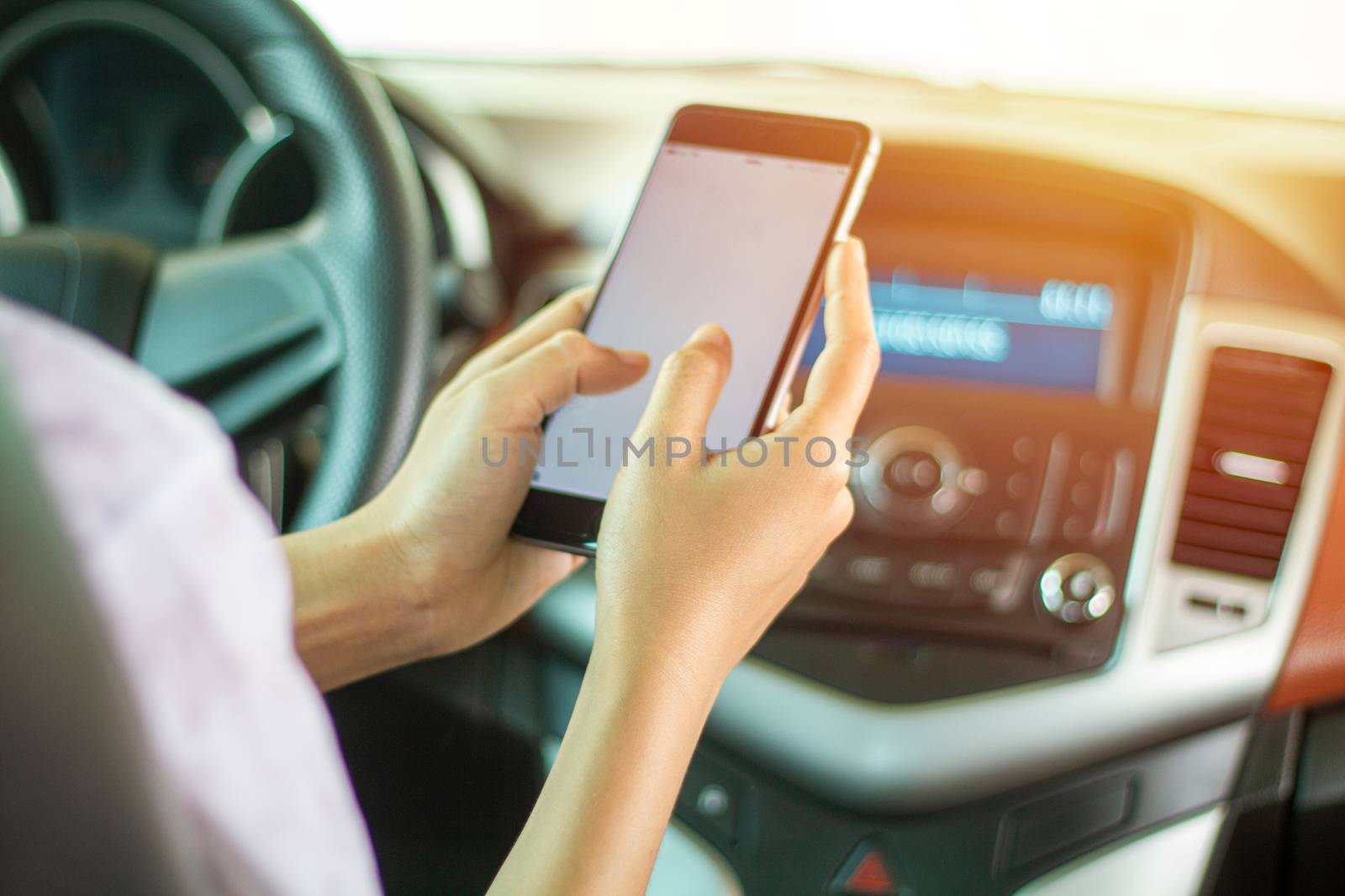 Asian women are driving cars and using a smartphone on the road.