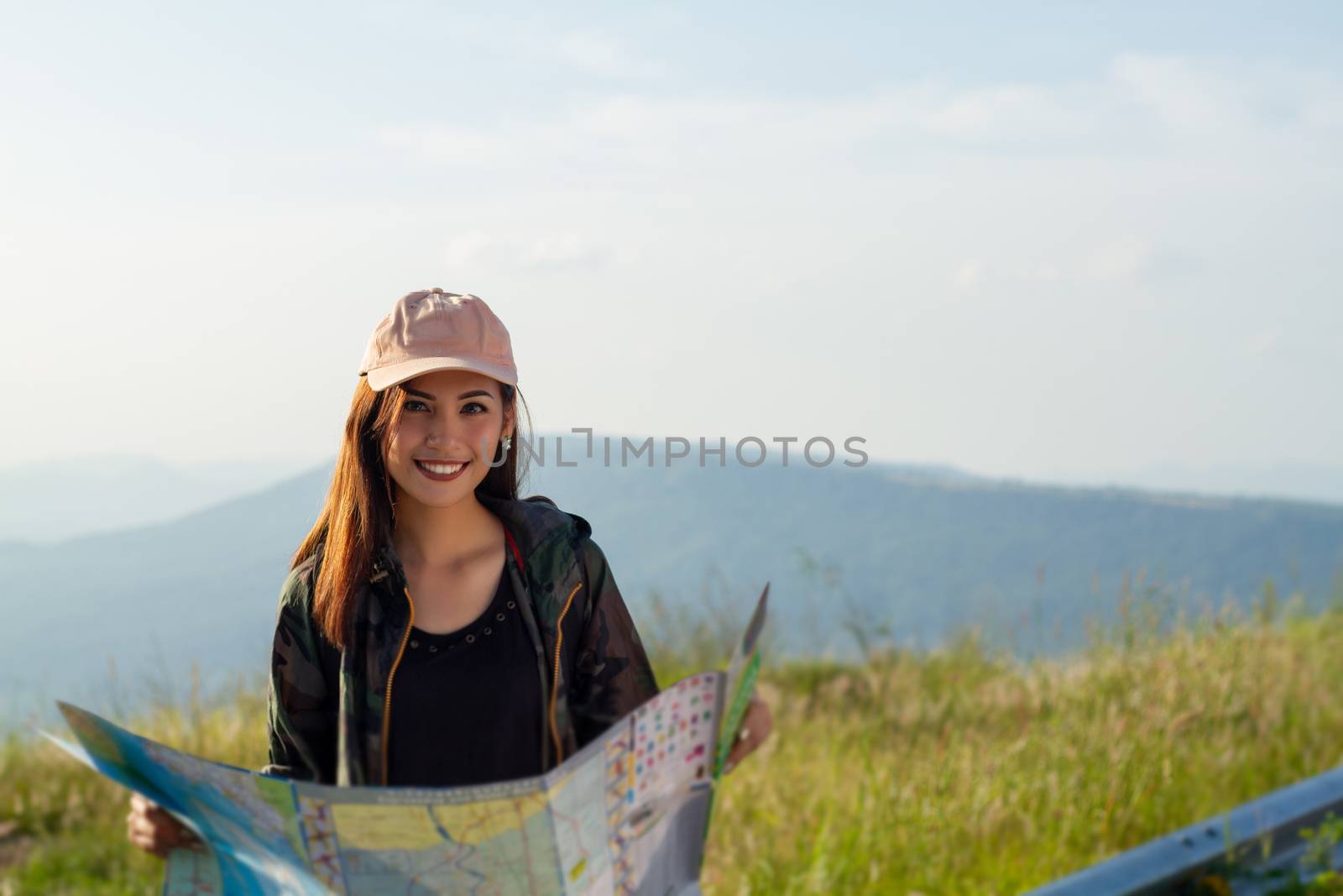 women asian with bright backpack looking at a map. View from back of the tourist traveler on background mountain, Female hands using smartphone, holding gadget