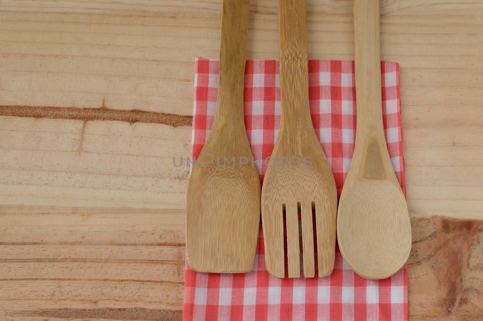 Wooden kitchen utensils on wooden background by Kheat