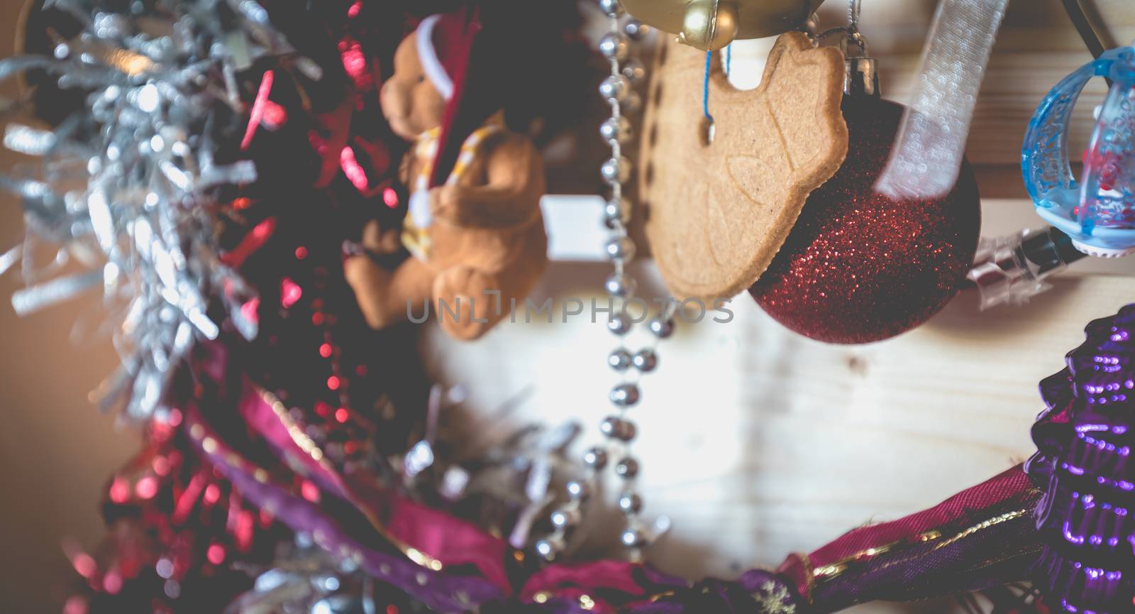 Christmas decoration made by children garlands, balls and pine cone on a fir tree made from wooden board at home