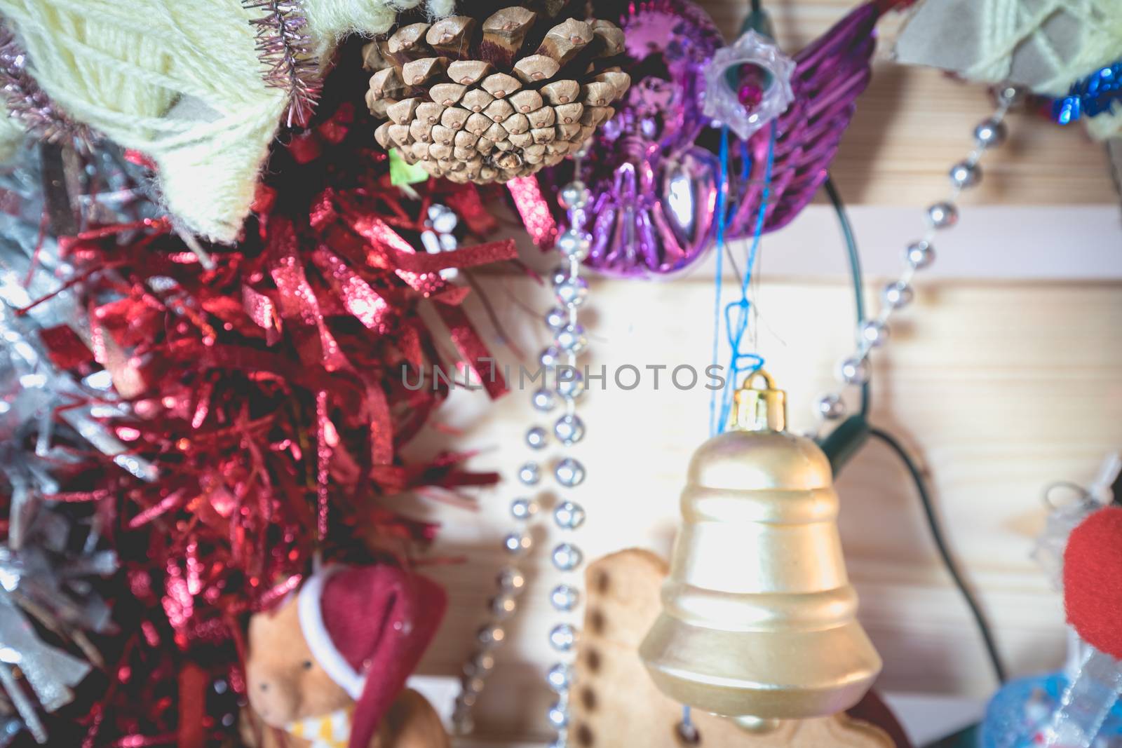 Christmas decoration made by children garlands, balls and pine cone on a fir tree made from wooden board at home