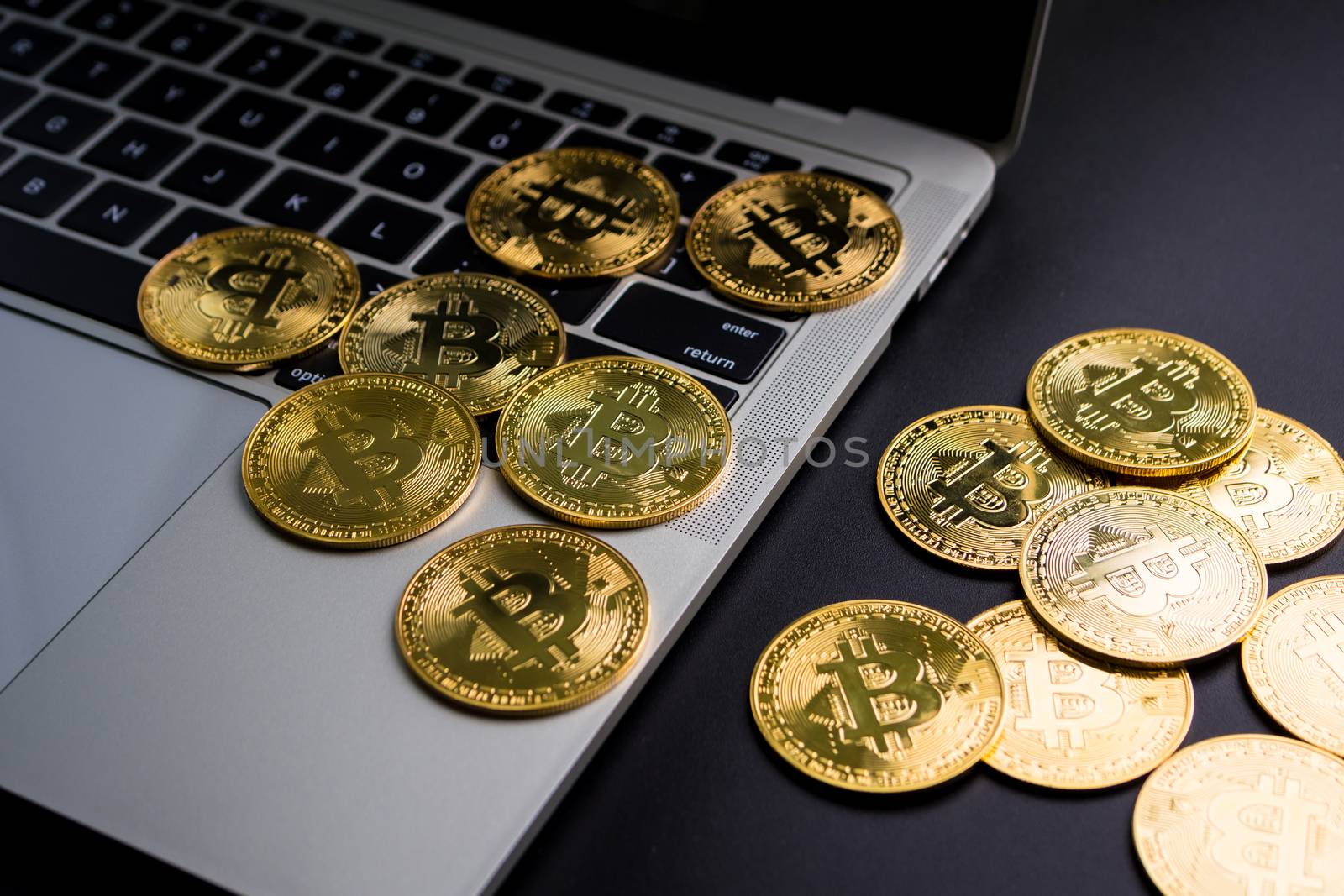 Golden coins with bitcoin symbol on computer keyboard and a black background.