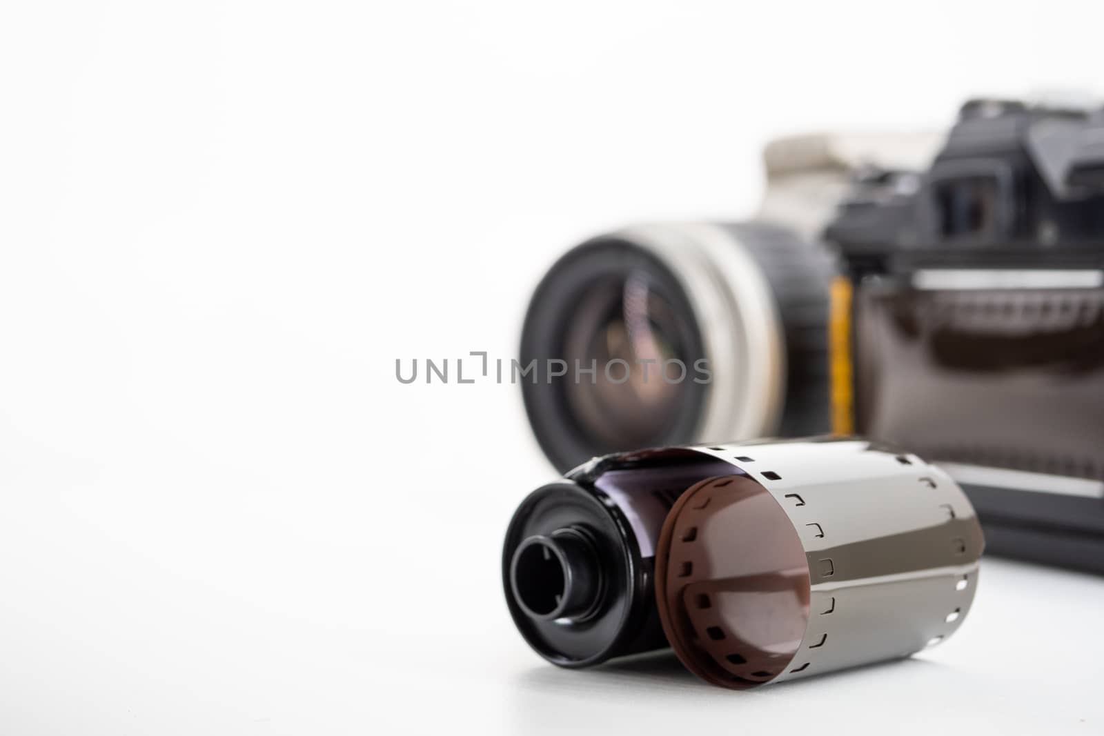 Single lens reflex cameras and film rolls on a white background.