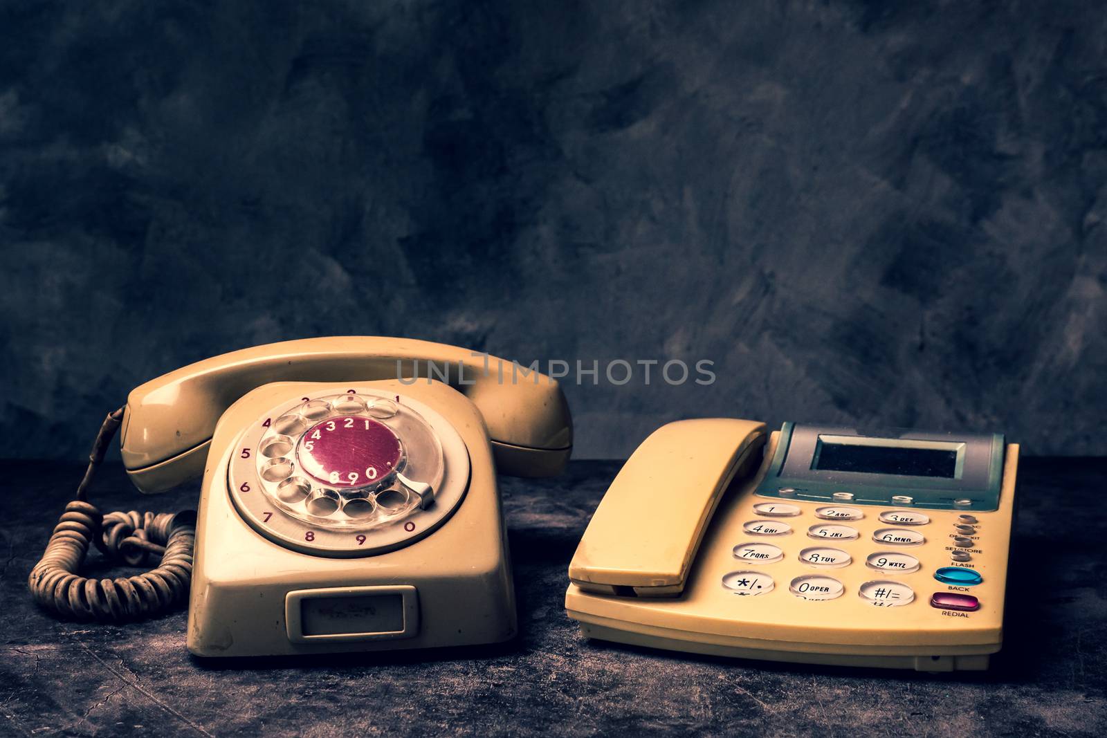 An old telephone with rotary dial and a landline on a grunge bac by ronnarong