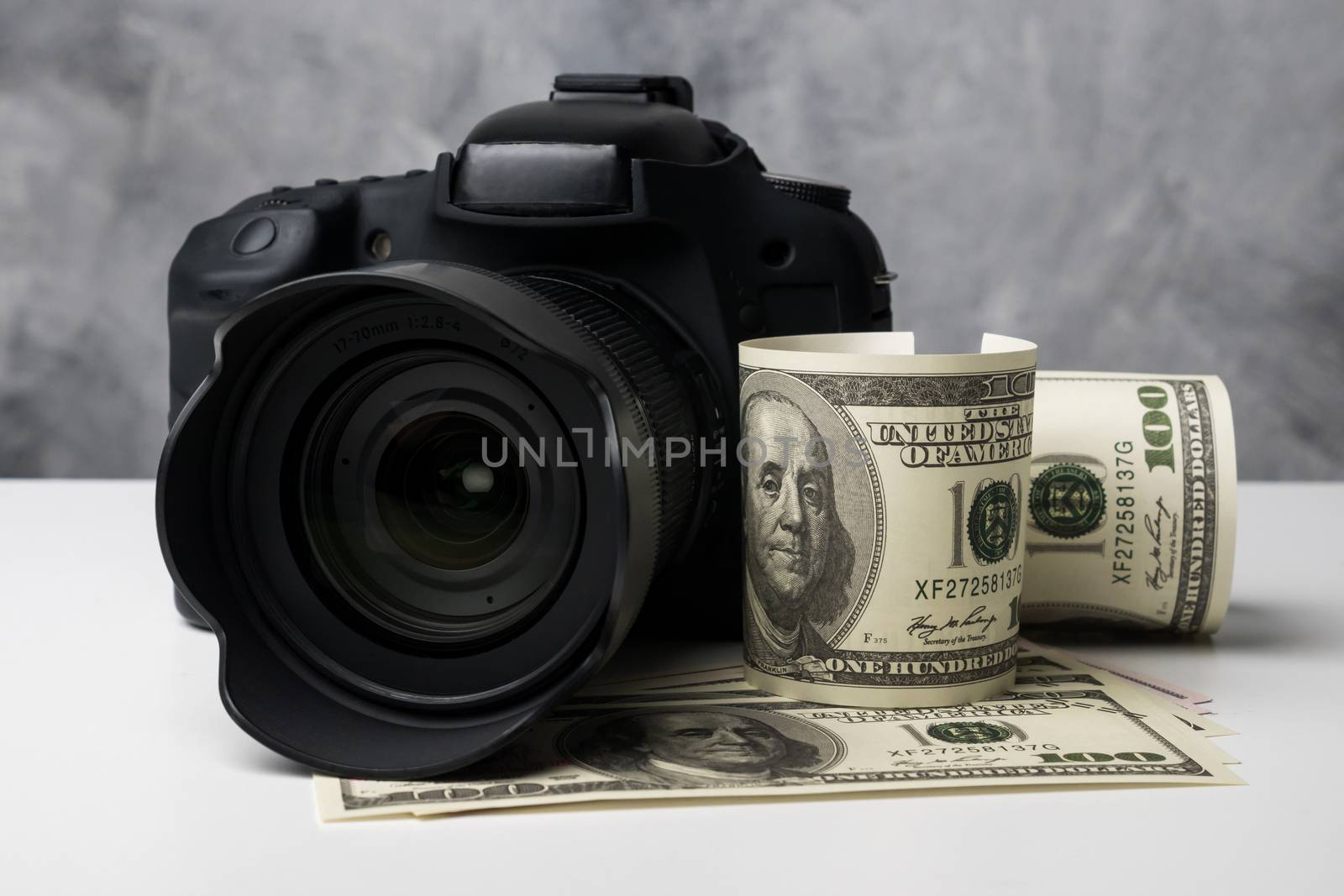 A black digital camera and banknotes on a white table with grung by ronnarong