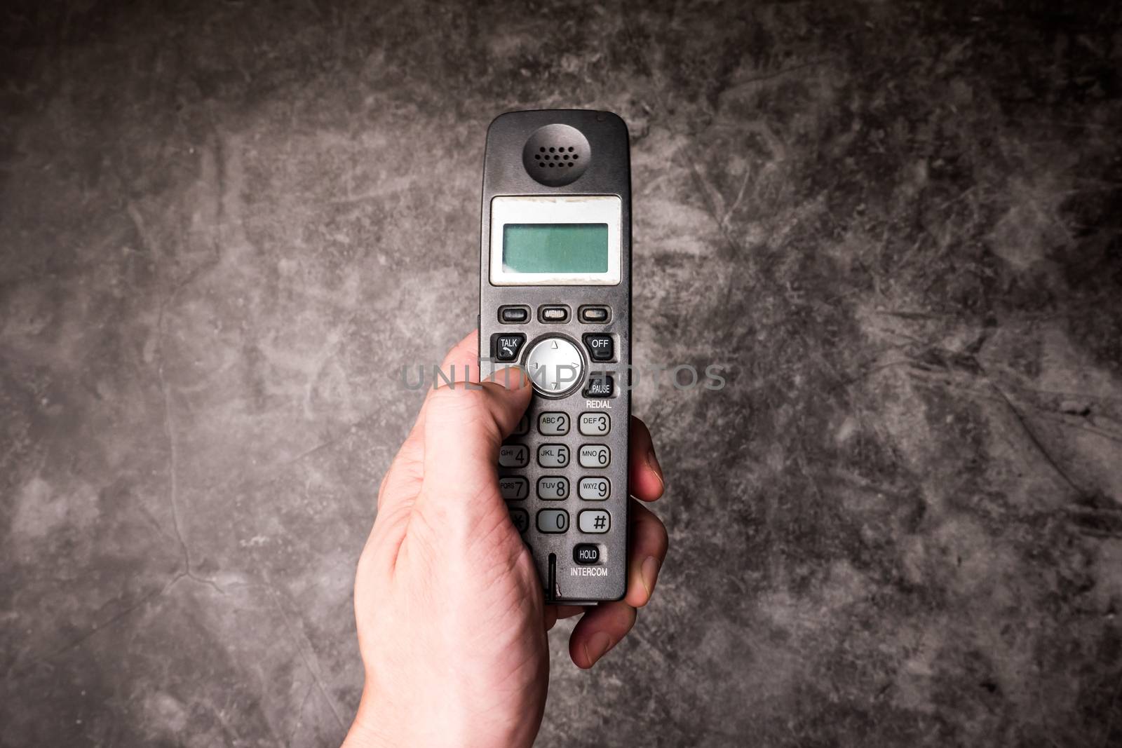 Close up of male hand press on button of an obsolete cellphone. by ronnarong