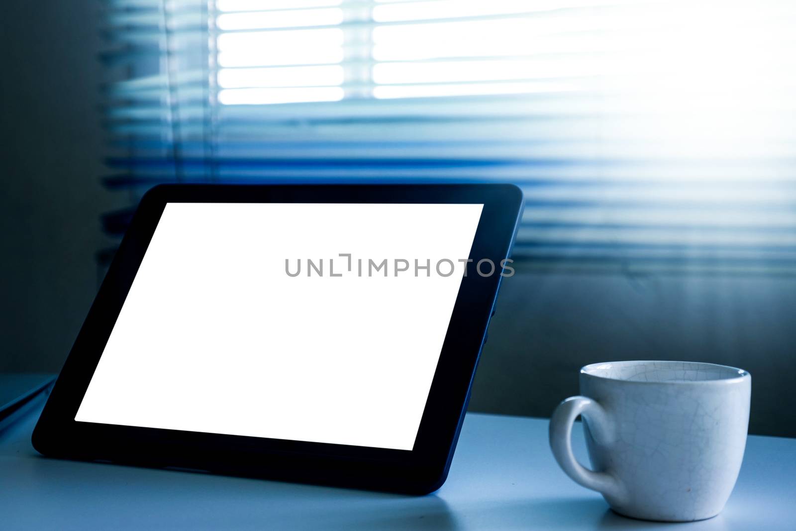 Blank screen tablet computer and a cup of coffee on the table by ronnarong