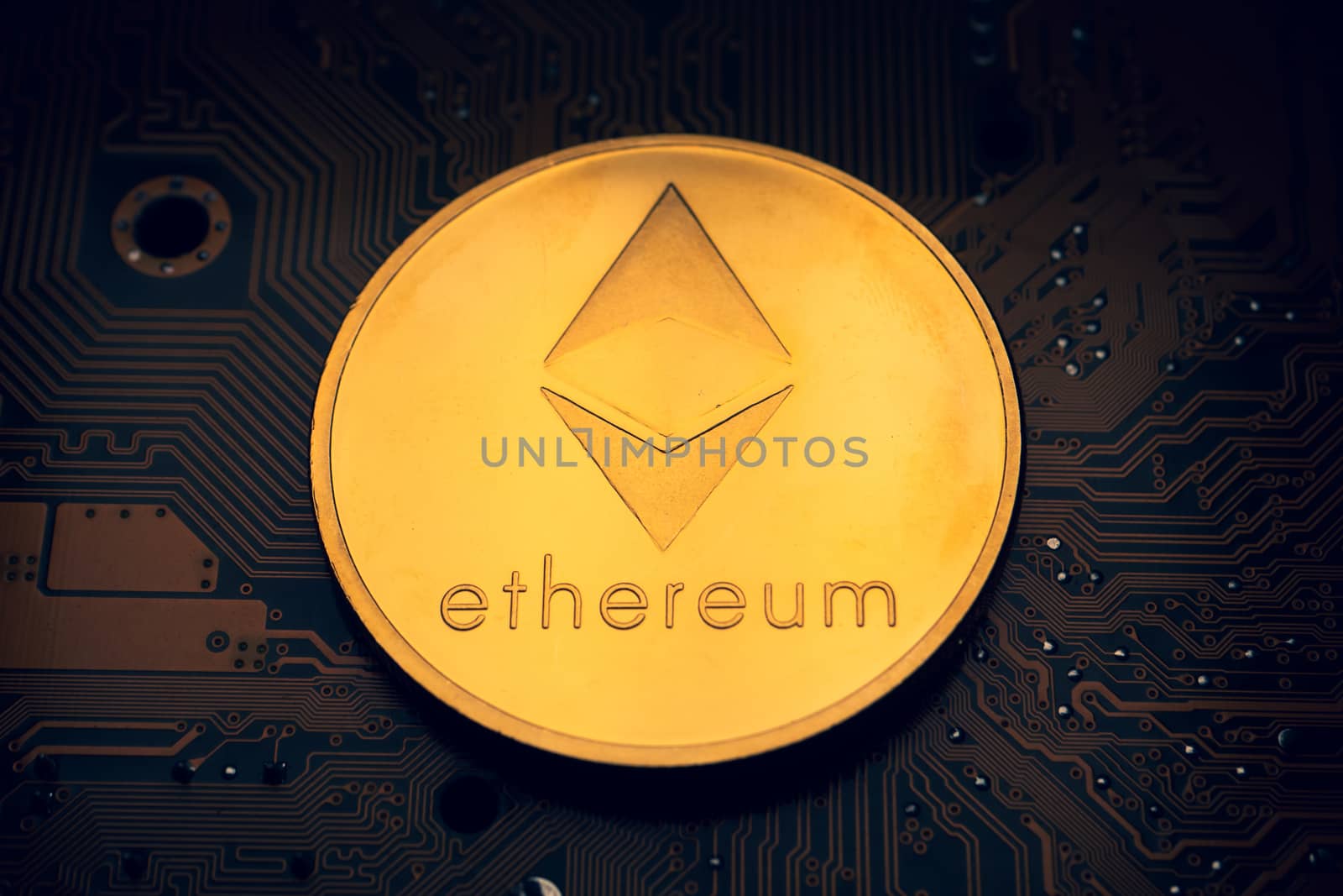 A golden coin with ethereum symbol on a mainboard.
