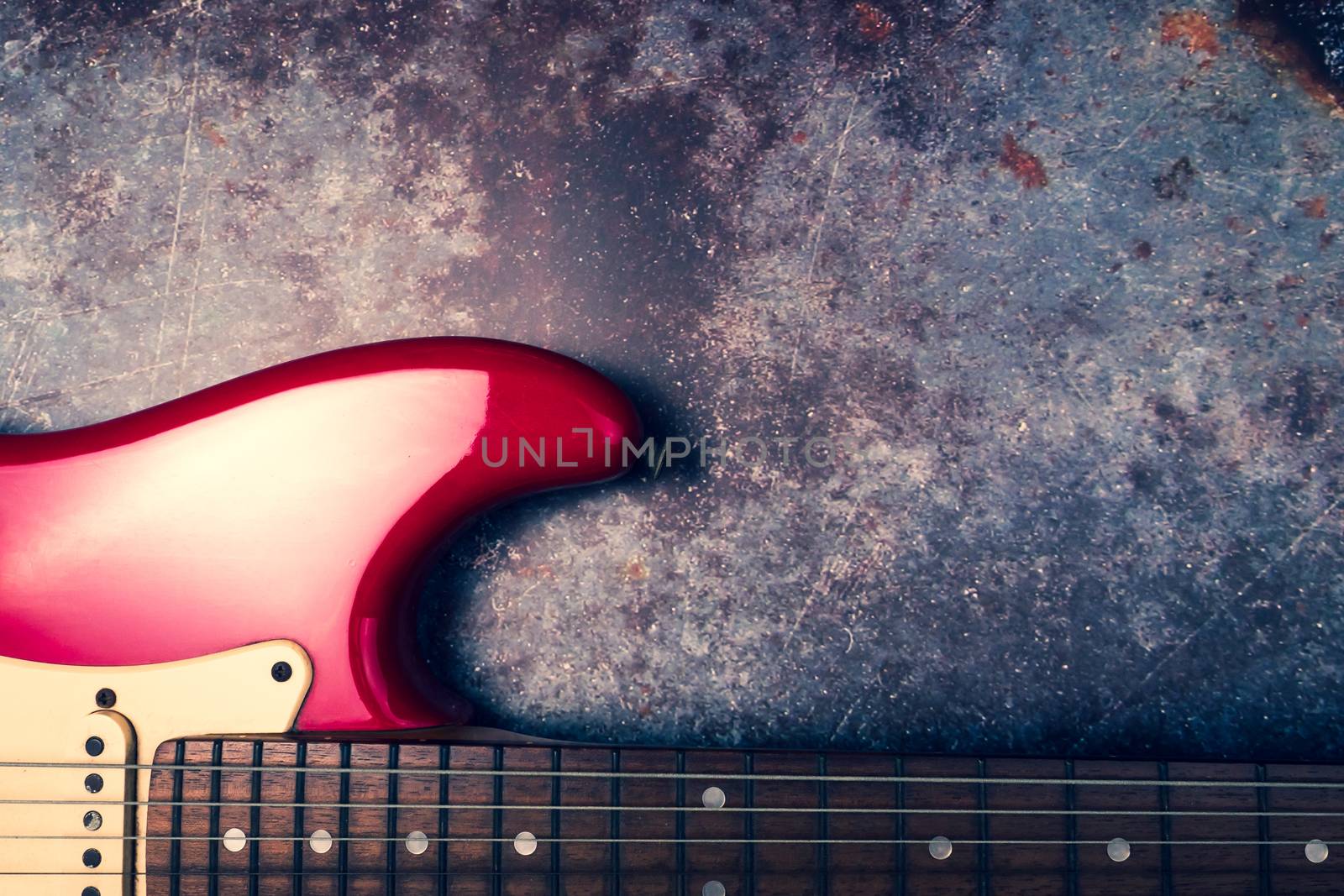 A red electric guitar on a grunge background.