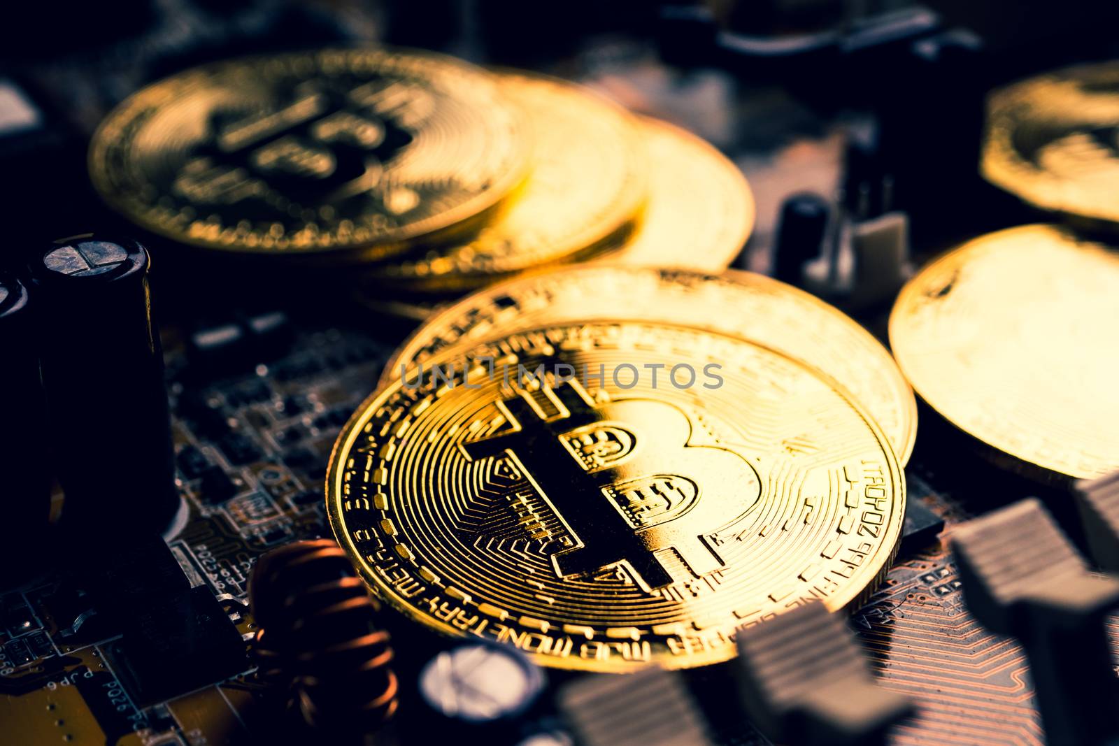 Golden coins with bitcoin symbol on a mainboard. by ronnarong