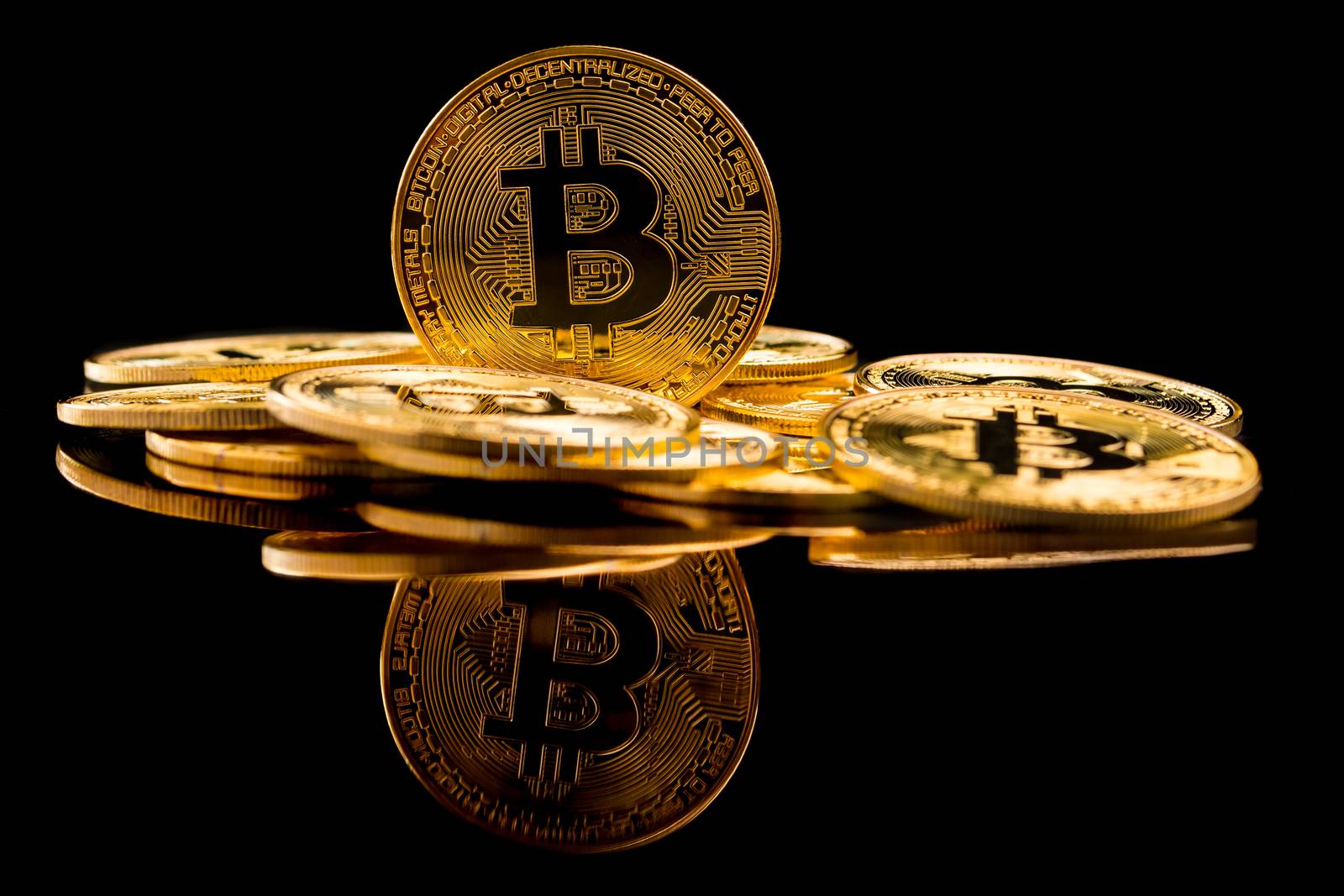 Golden coins with bitcoin symbol on a black background.