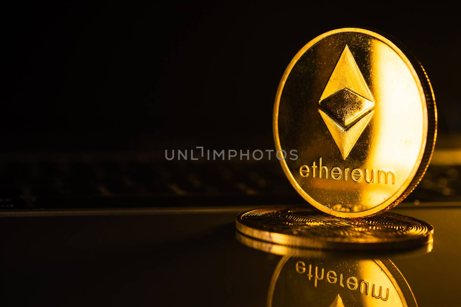 Golden coins with ethereum symbol on computer.