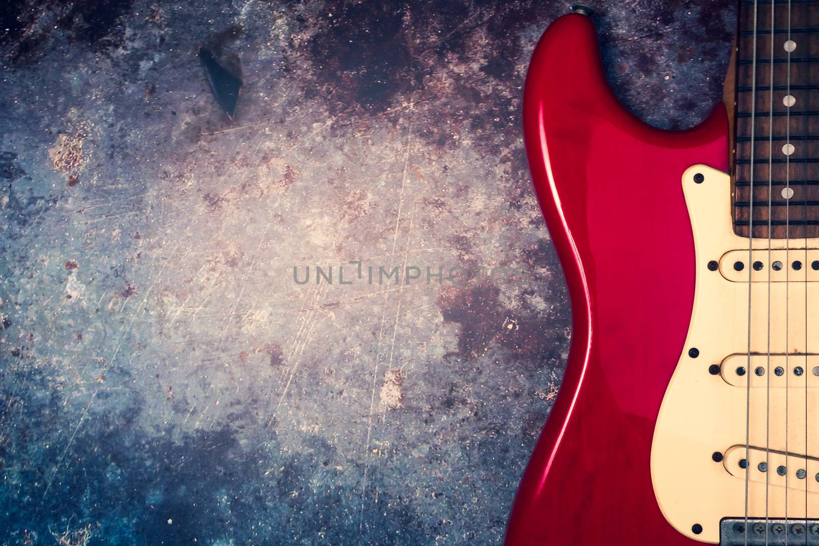 A red electric guitar on a grunge background.