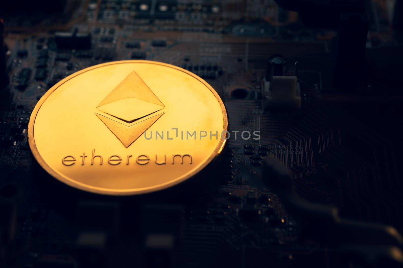 A golden coin with ethereum symbol on a mainboard. by ronnarong