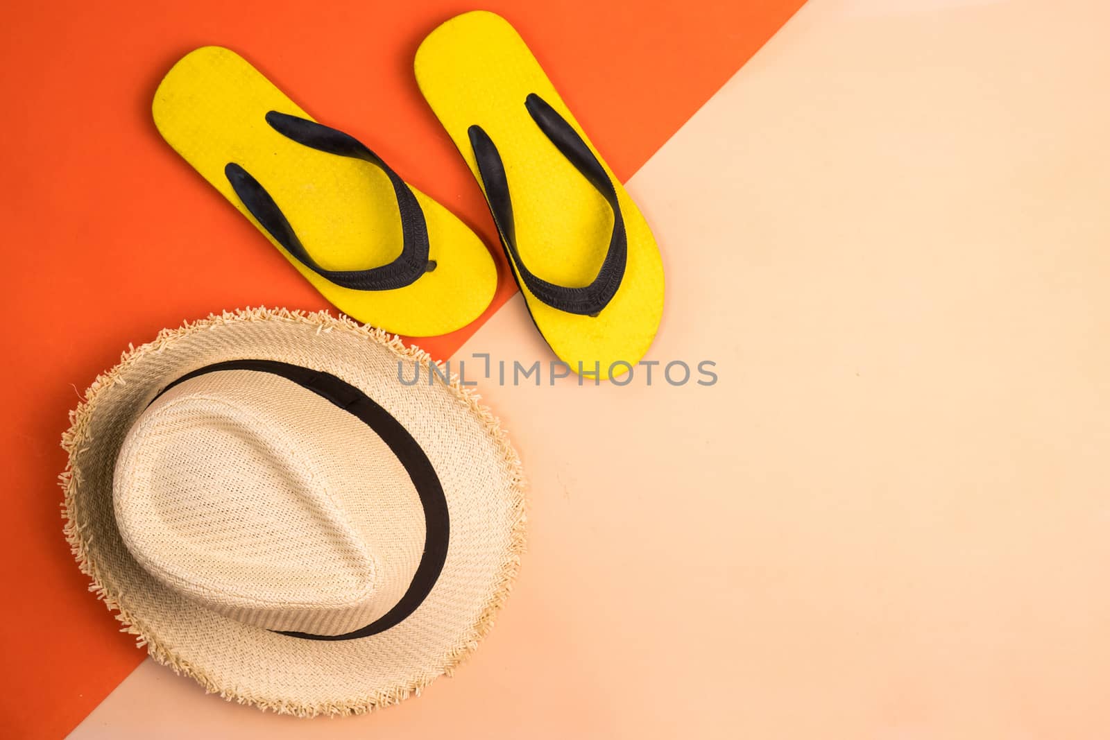 Beach hat and rubber slippers on colors background.