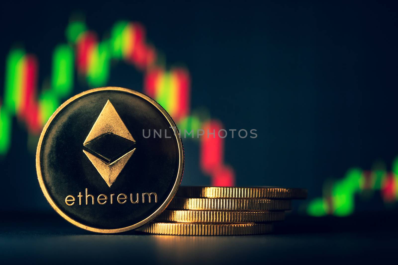 Stack of golden coins with ethereum symbol with stock graph back by ronnarong