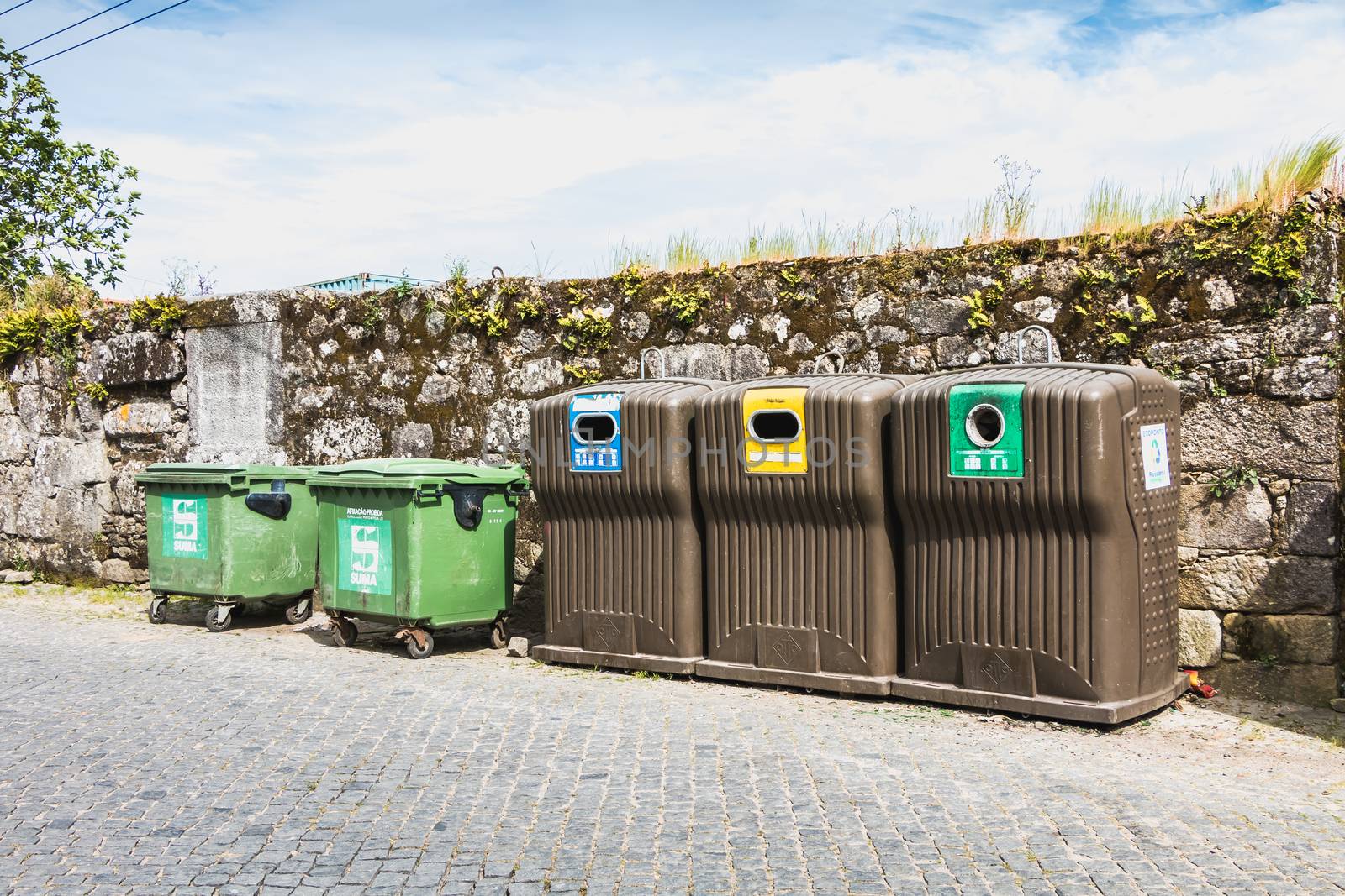 Public recycling bins in front of a stone wall in vila cha, port by AtlanticEUROSTOXX
