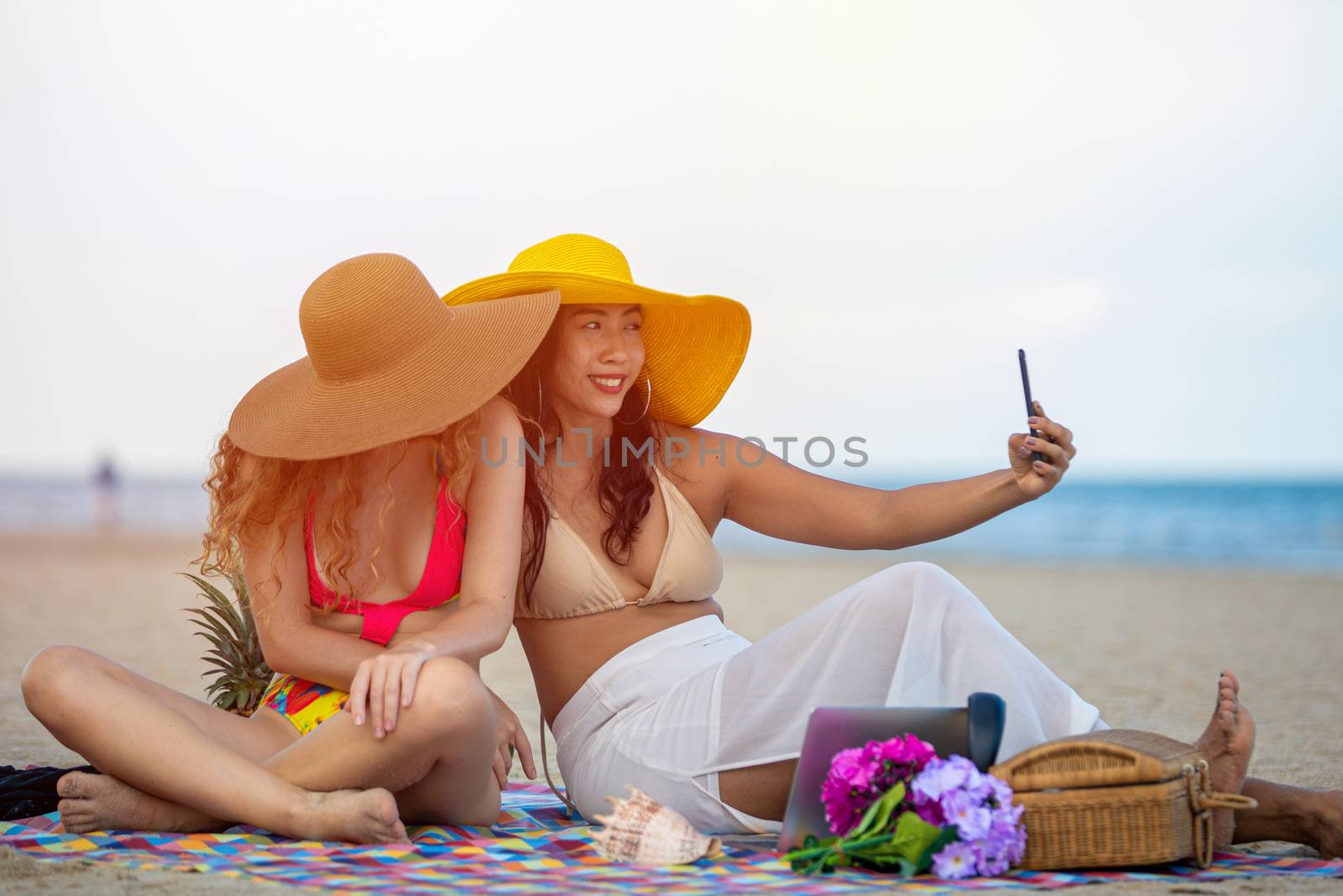 Women are taking photos and Selfie with friends on the sand beach in the summer.