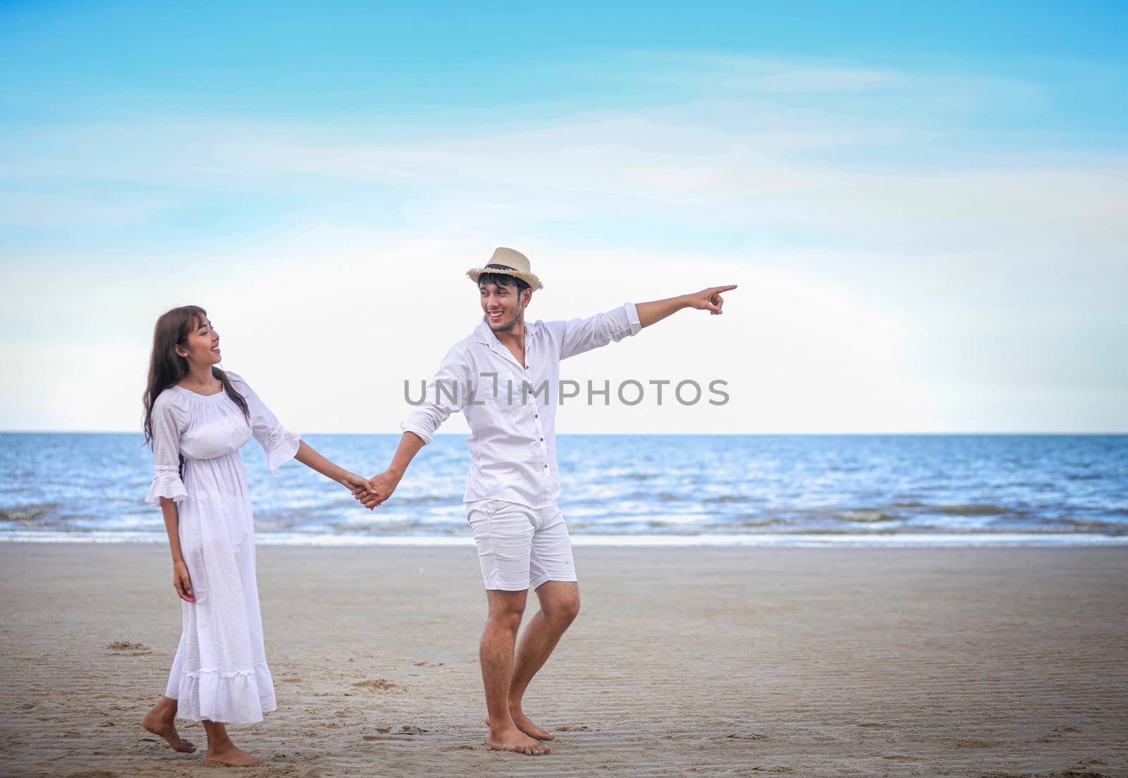 Happy Romantic Couples lover holding hands together walking on the beach