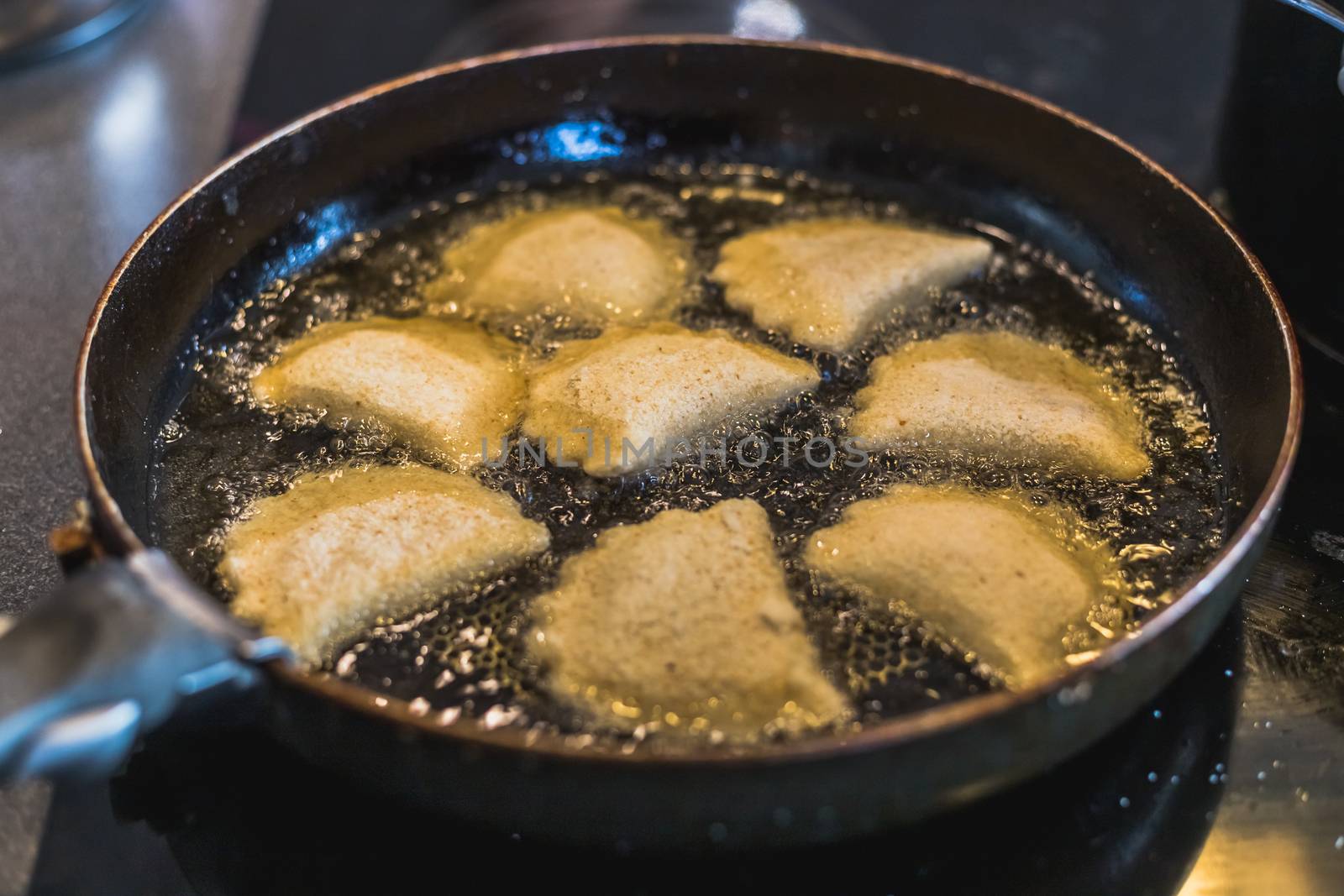 fried portuguese or brazilian rissoles in a pan in a kitchen