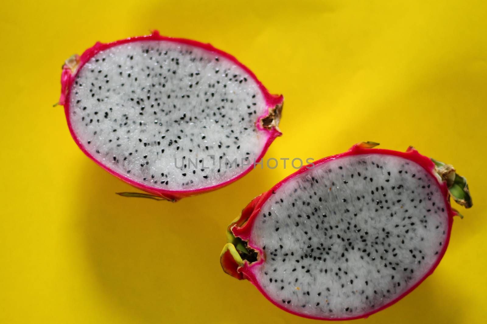 Fresh sliced dragonfruit or pitaya against a vibrant yellow background by Sonnet15