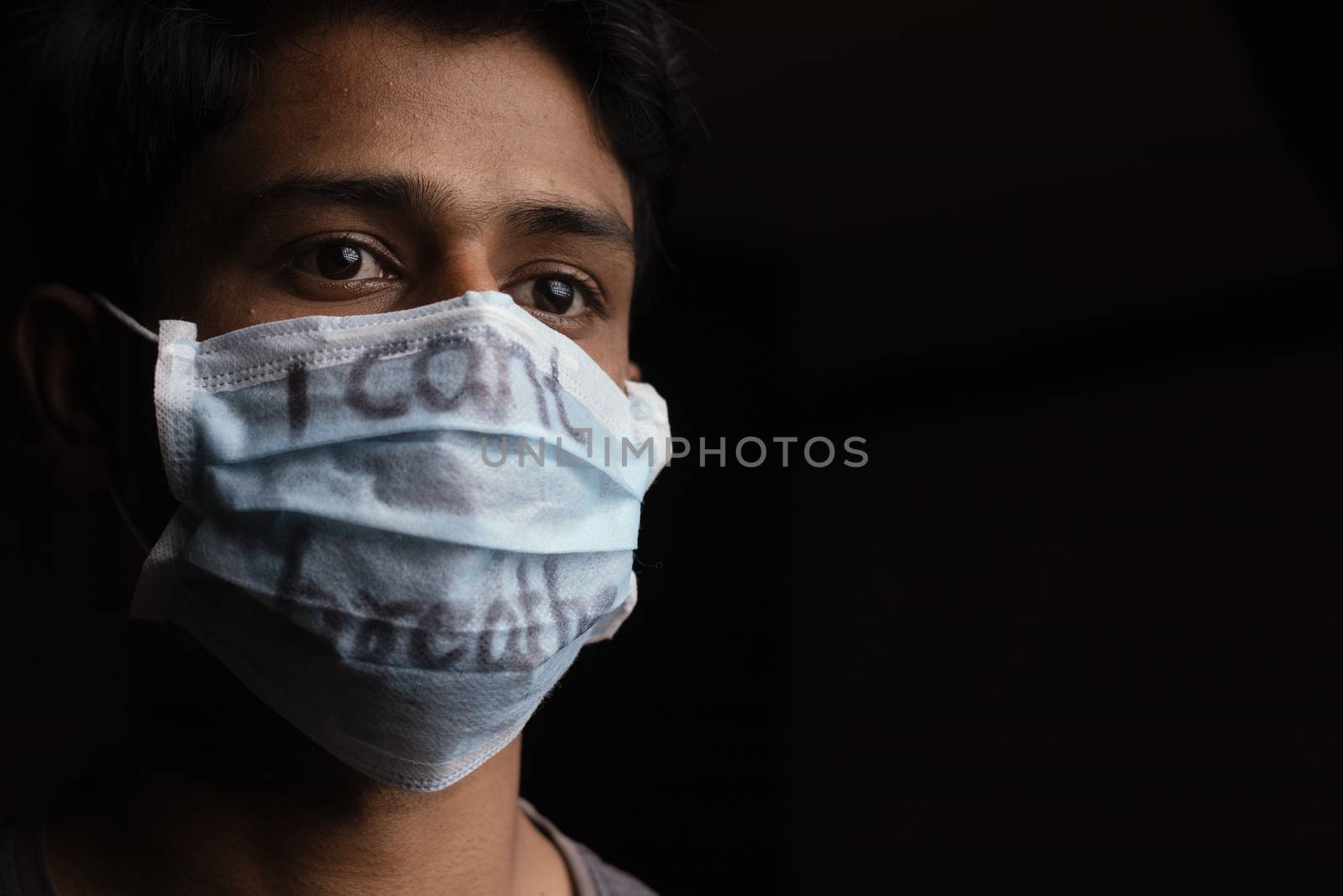 Young man with wearing I Can't Breathe inscription on medical face mask with copy space. Cooncept of Protest about Human Right of Black People in U.S. America by lakshmiprasad.maski@gmai.com