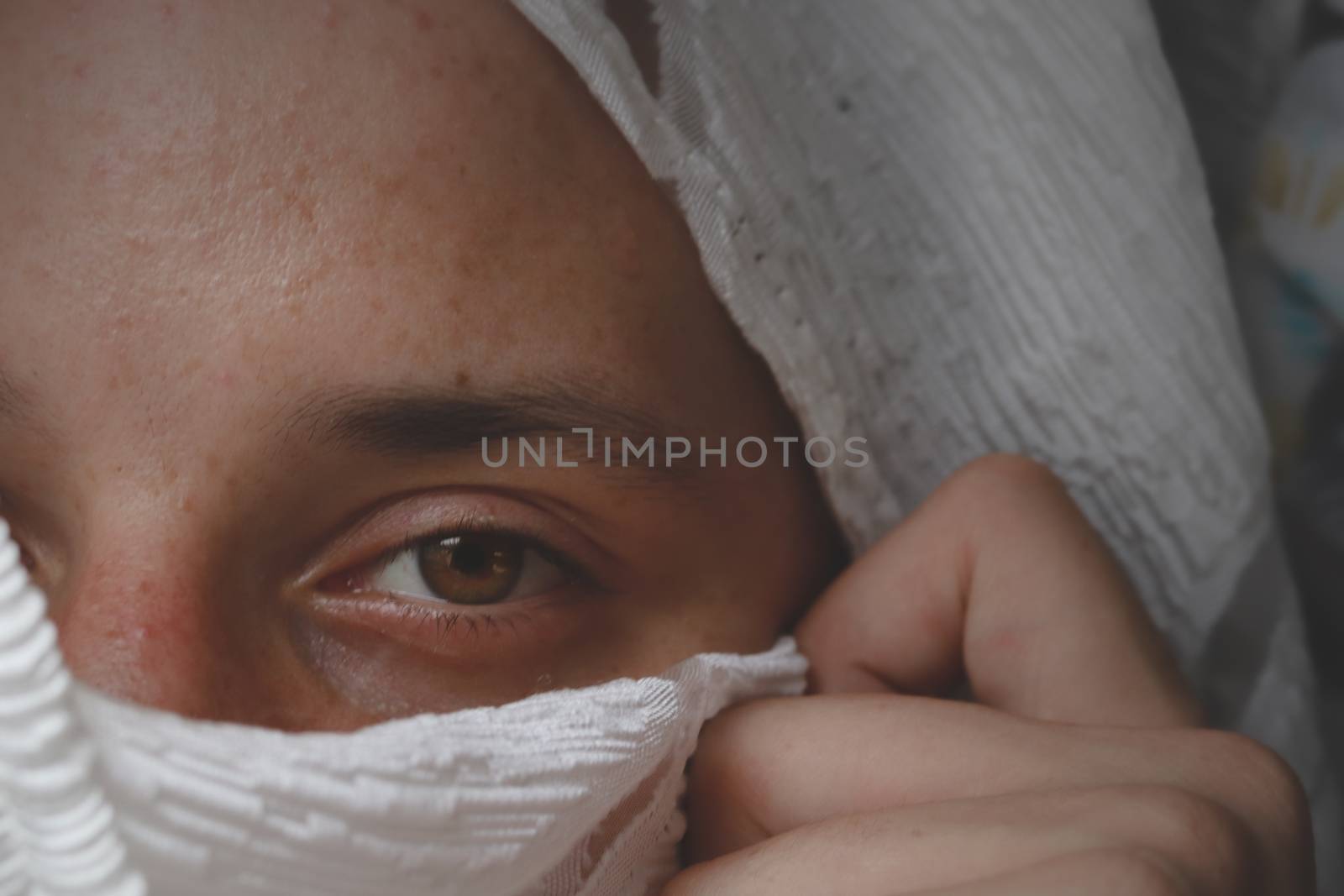 Conceptual portrait of a man hidden in a veil to show concept of male vulnerability, intimacy, gender identity, secrecy and mental health