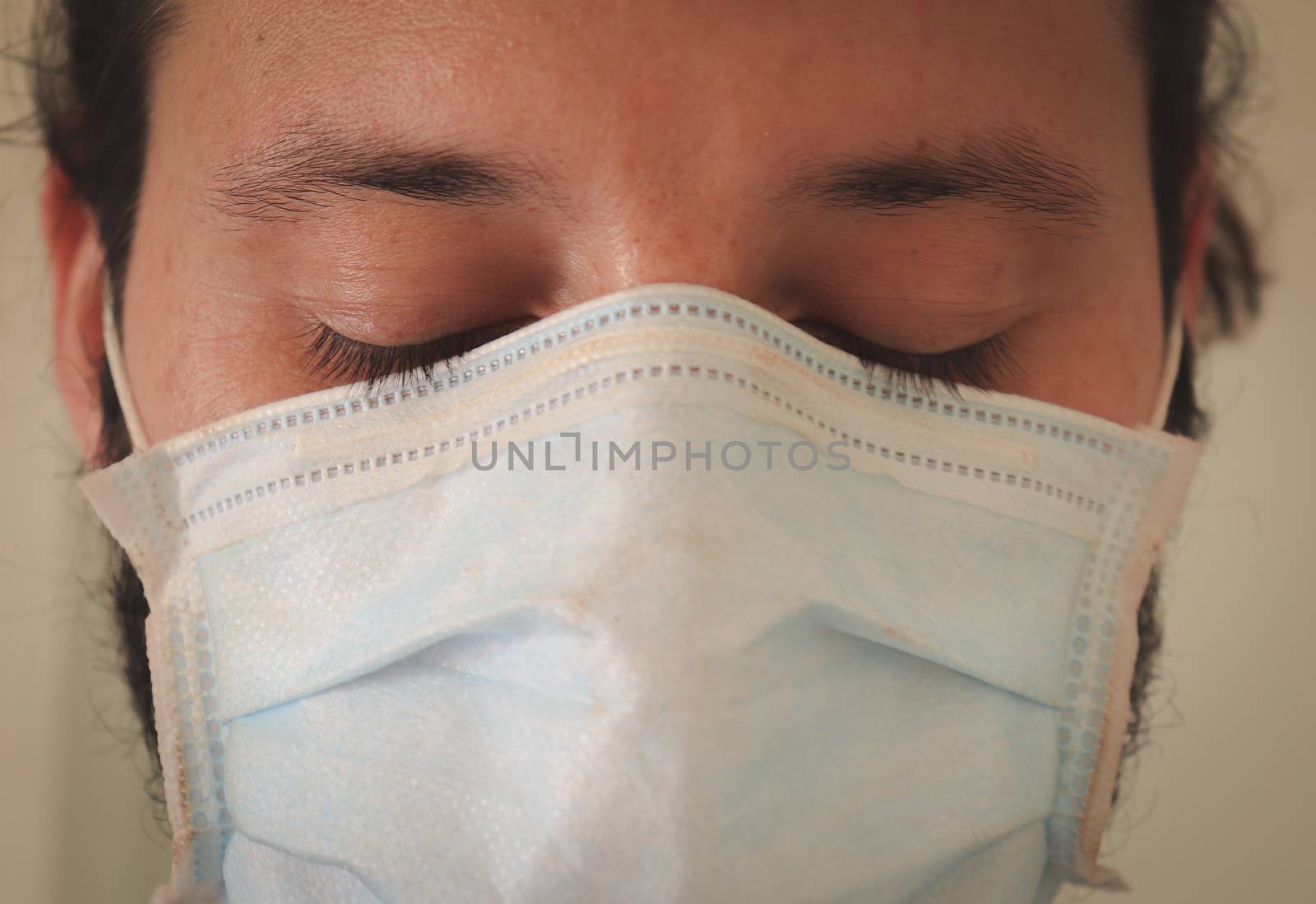 Portrait of a man wearing a surgical mask to show the concept of fighting the global pandemic which is the covid-19 with personal protective equipment or PPE