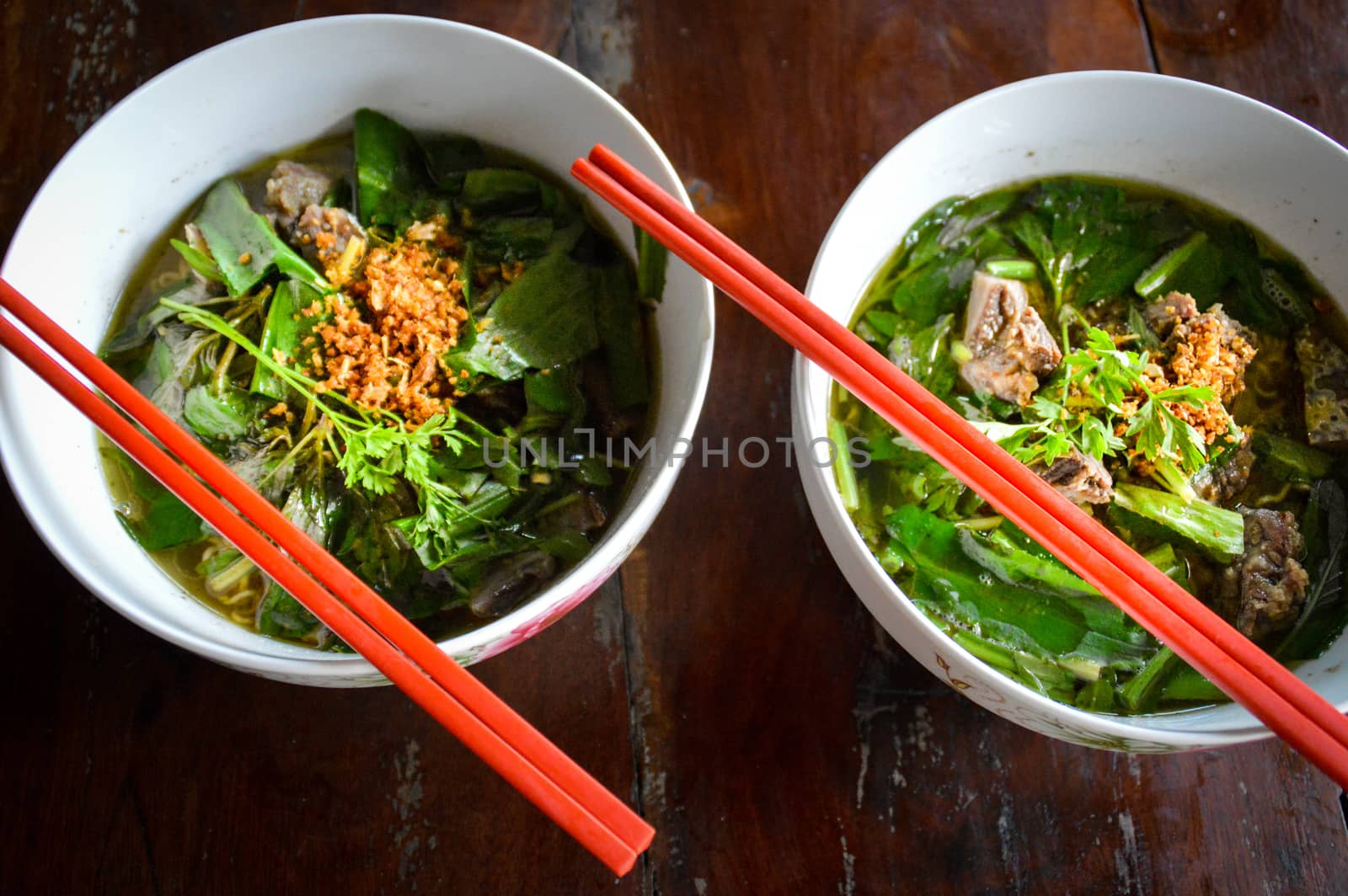 Top view of two bowls of traditional khmer noodles soup called Kuyteav or katiew