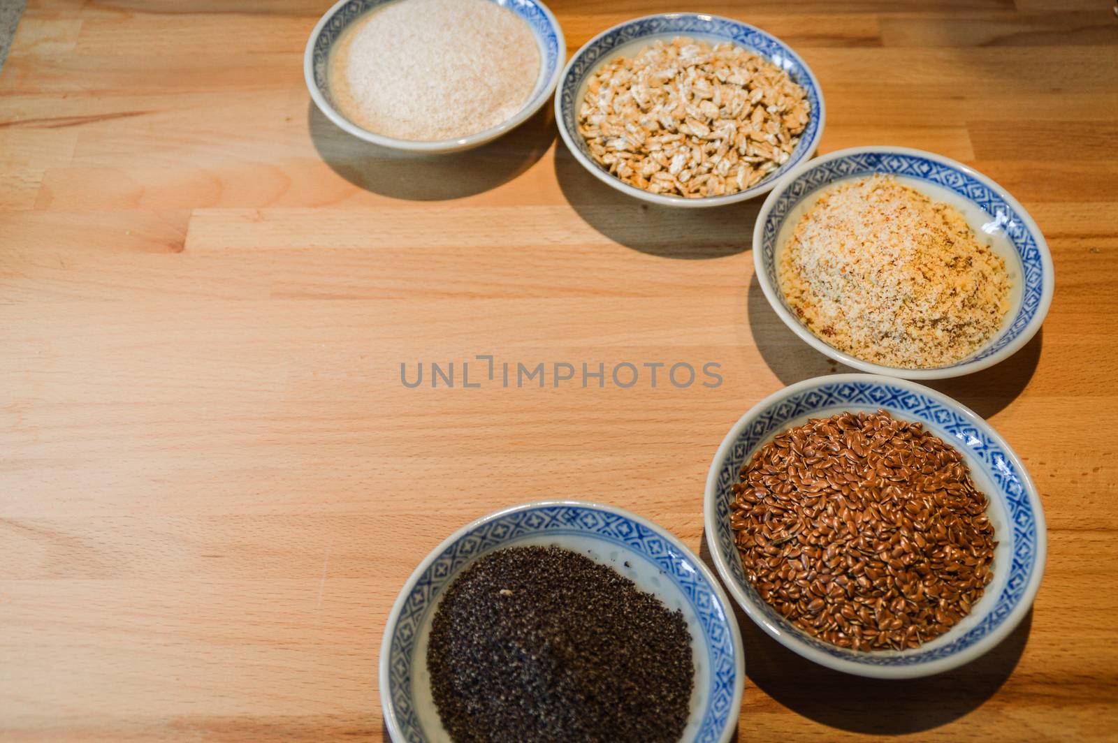 Various grains of oats, millet and ground nuts in plates for baking gluten-free bread